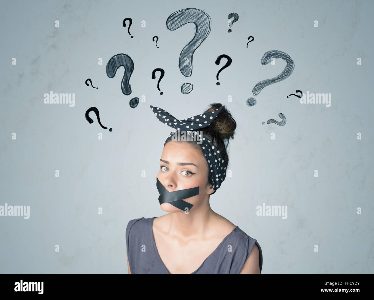 Jeune femme avec la bouche collée et symboles d'interrogation Banque D'Images