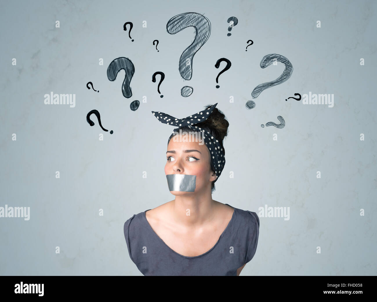 Jeune femme avec la bouche collée et symboles d'interrogation Banque D'Images