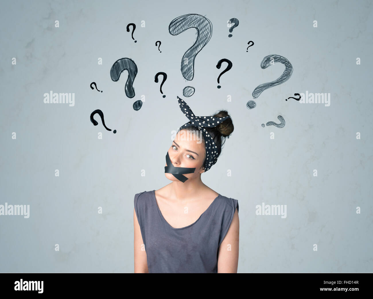 Jeune femme avec la bouche collée et symboles d'interrogation Banque D'Images