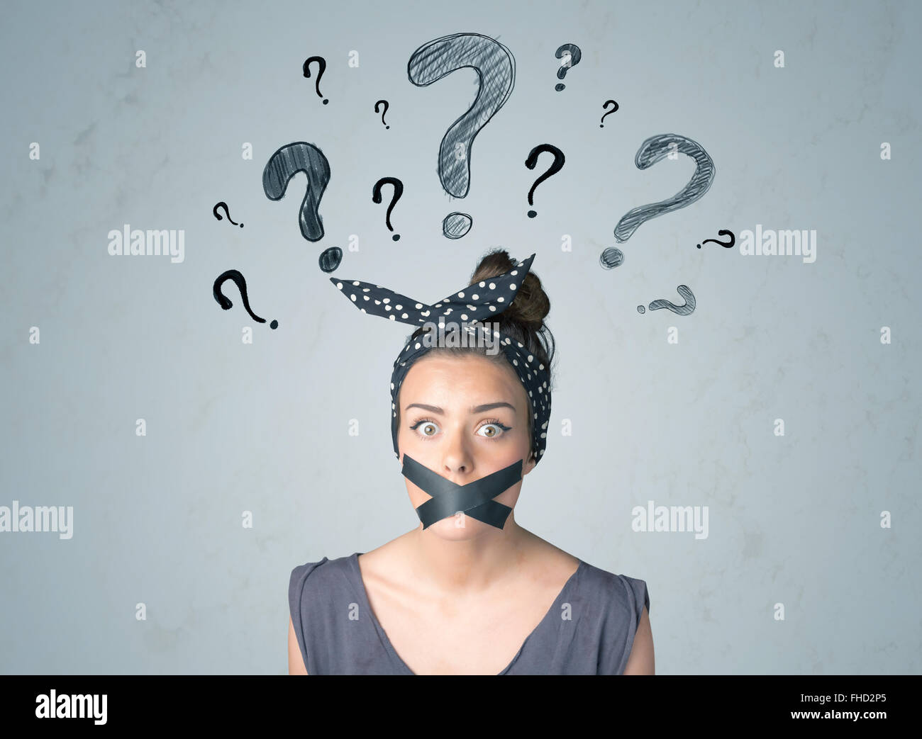 Jeune femme avec la bouche collée et symboles d'interrogation Banque D'Images