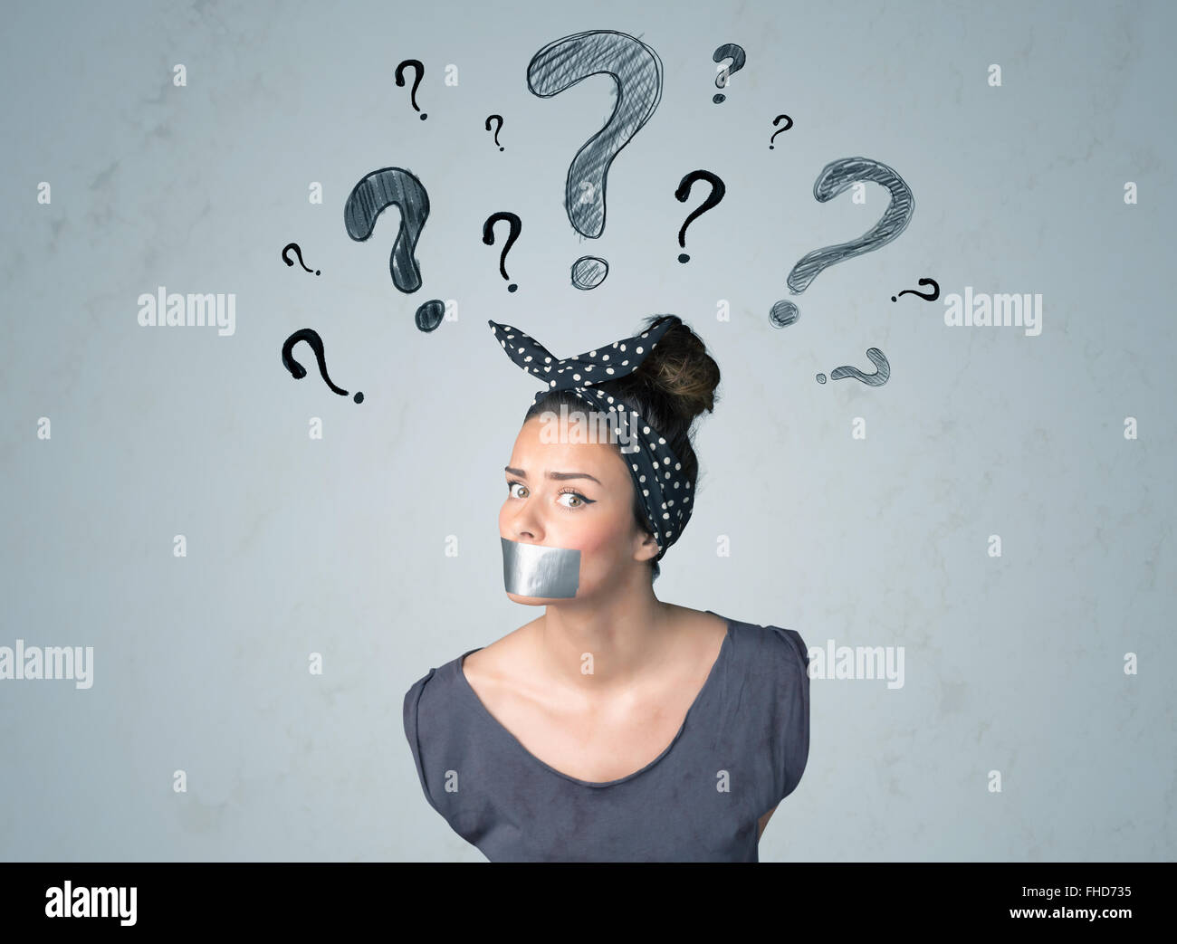 Jeune femme avec la bouche collée et symboles d'interrogation Banque D'Images