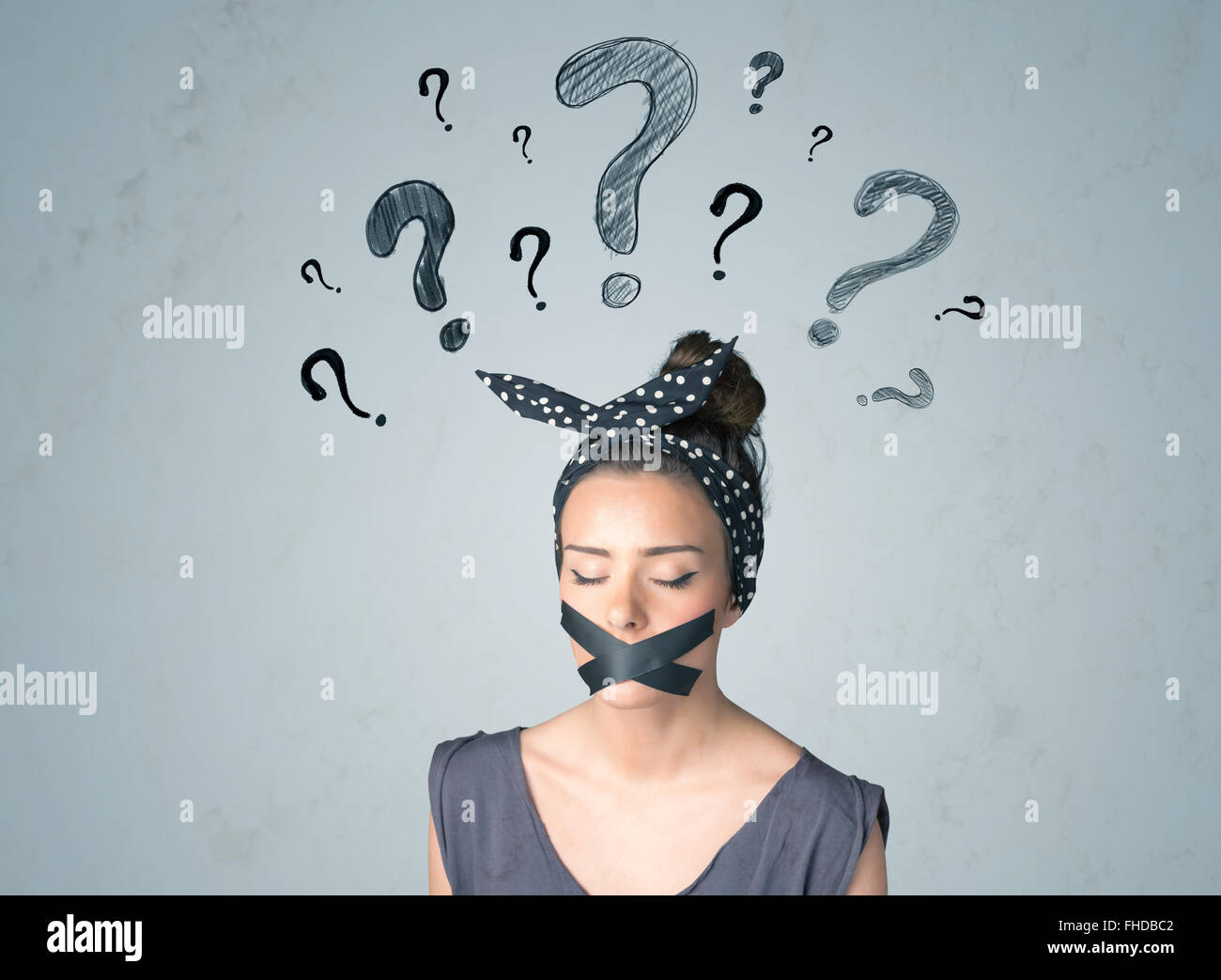 Jeune femme avec la bouche collée et symboles d'interrogation Banque D'Images