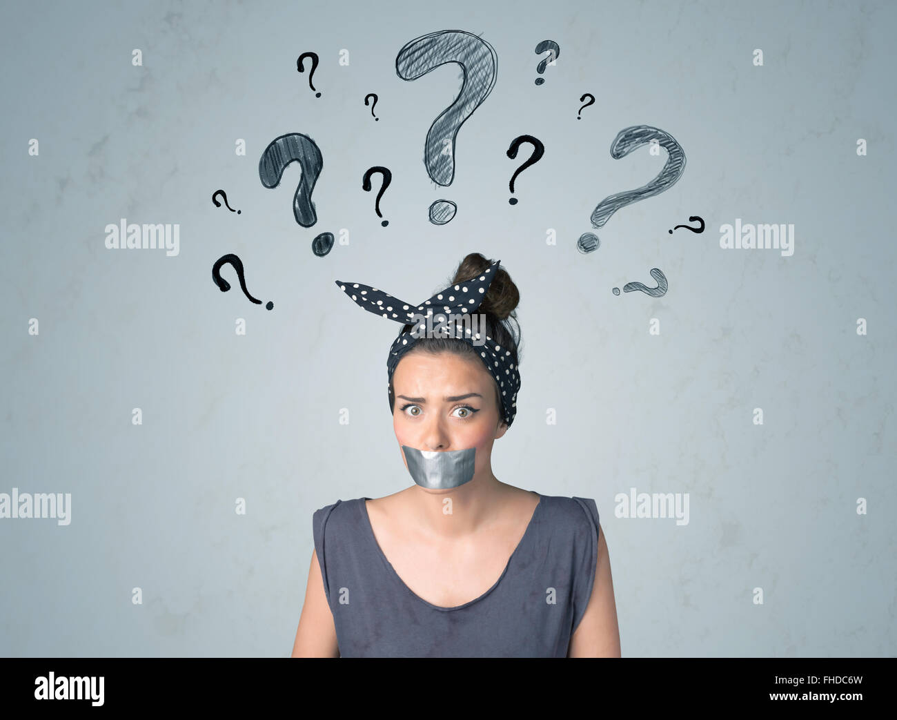 Jeune femme avec la bouche collée et symboles d'interrogation Banque D'Images