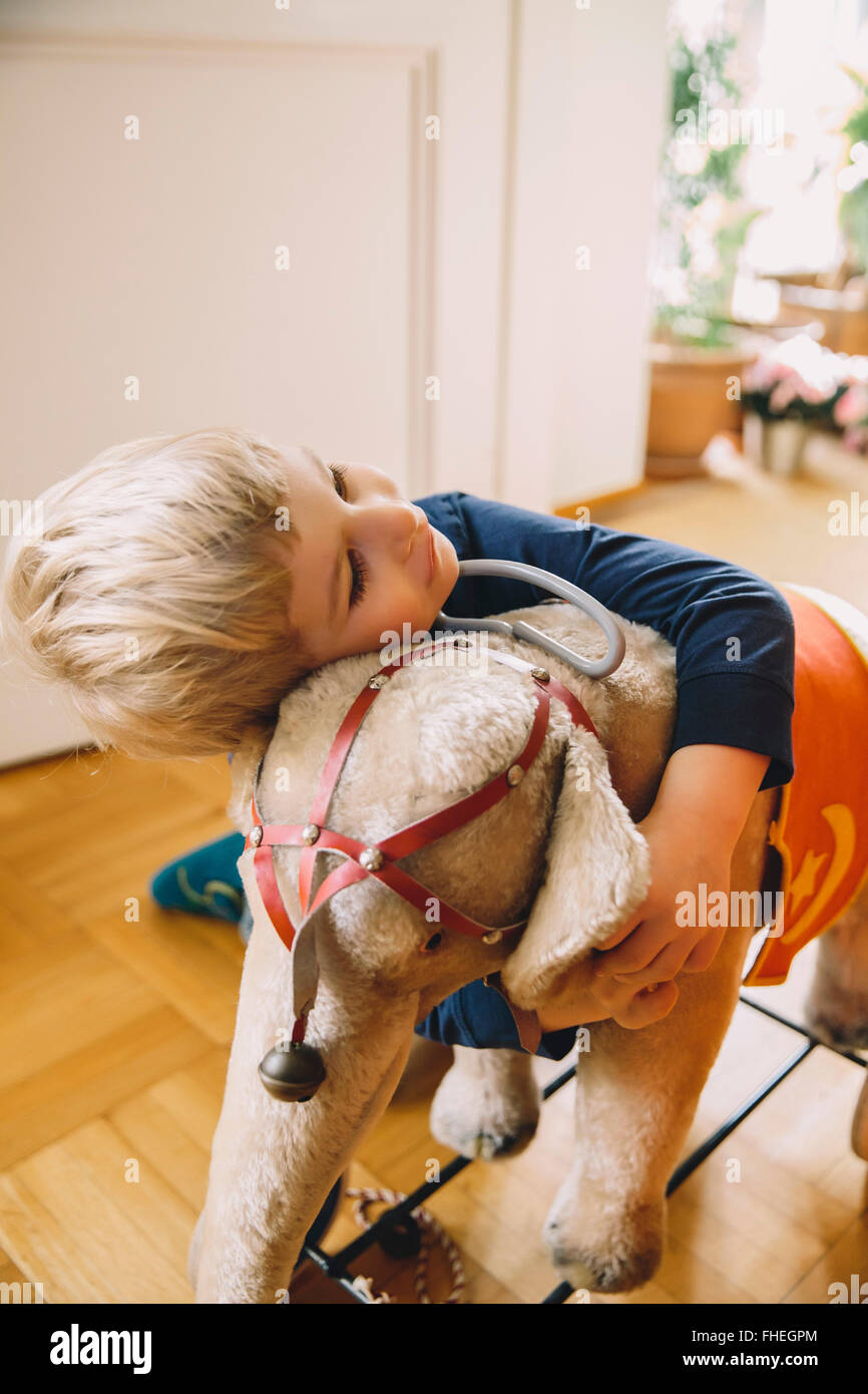 Boy hugging un vieil éléphant en peluche Banque D'Images