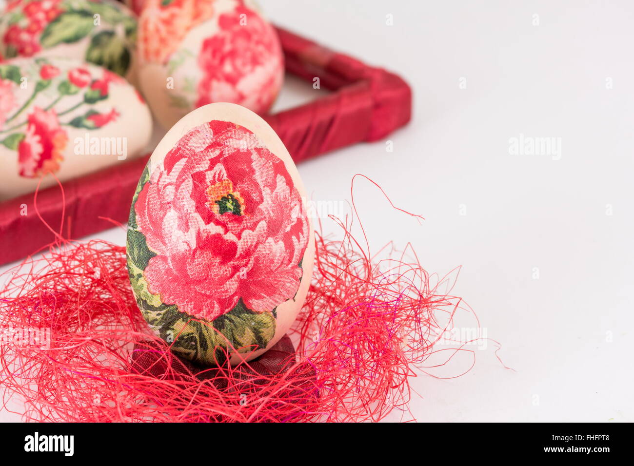 Oeufs de Pâques décorés Decoupage sur paille rouge Banque D'Images