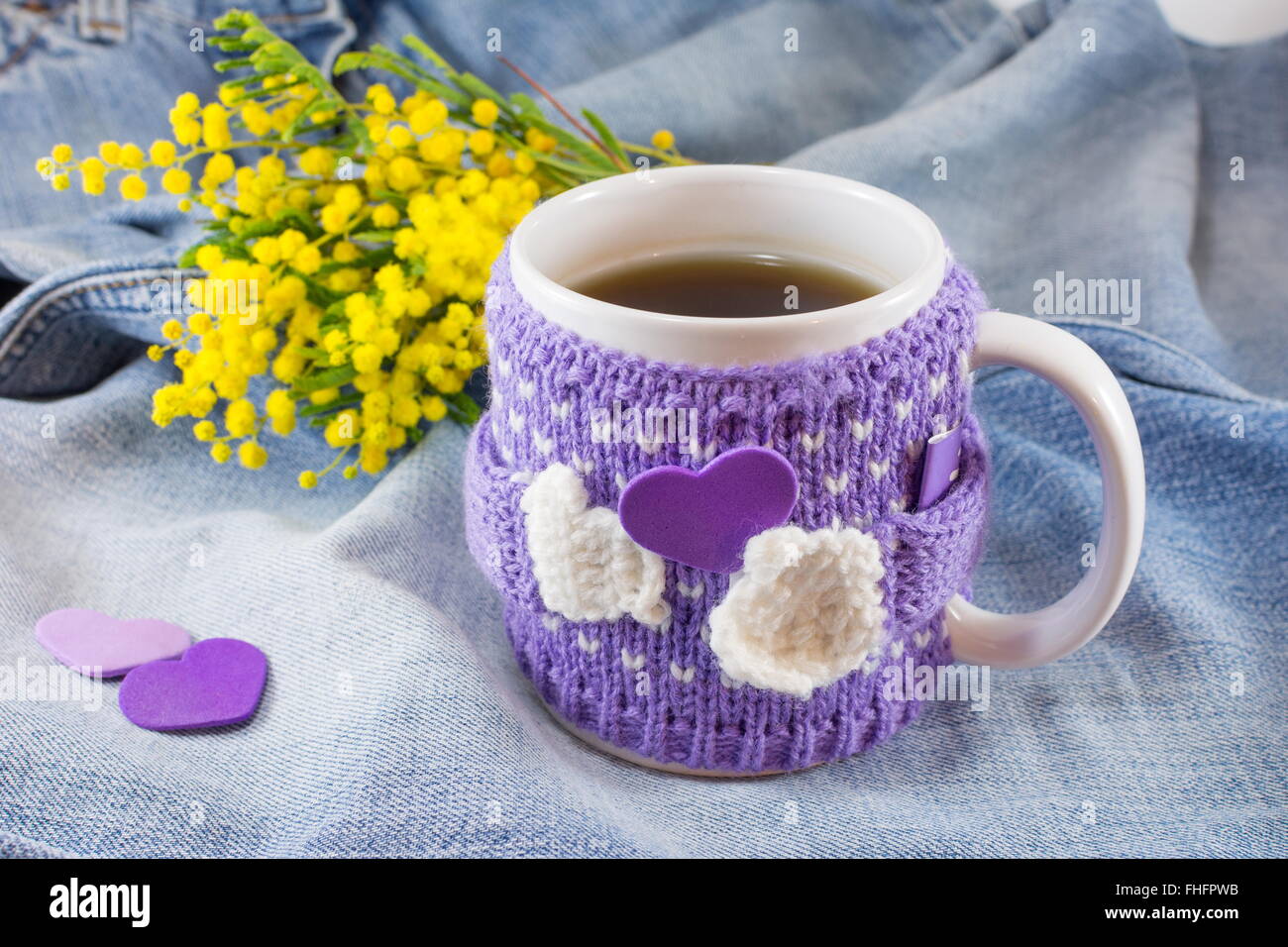 Tasse de thé d'hiver et mimosa fleurs sur fond bleu denim Banque D'Images