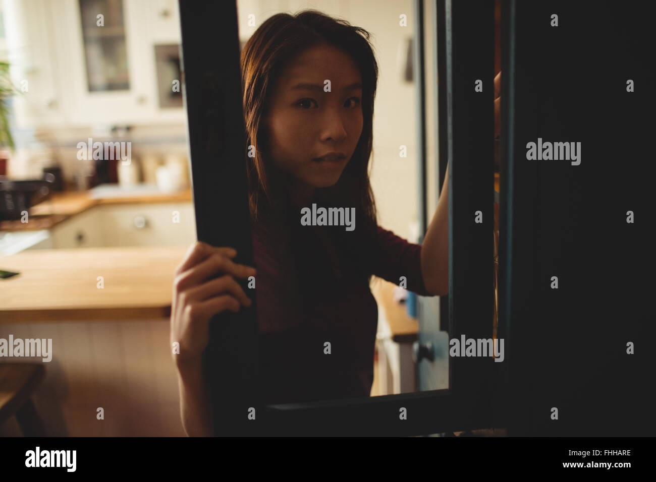 Brunette et regarde à l'intérieur de placard d'ouverture Banque D'Images