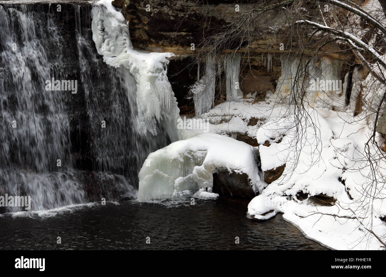 Chute d'hiver avec l'eau gelée et la glace sur les côtés et le bas des chutes Banque D'Images