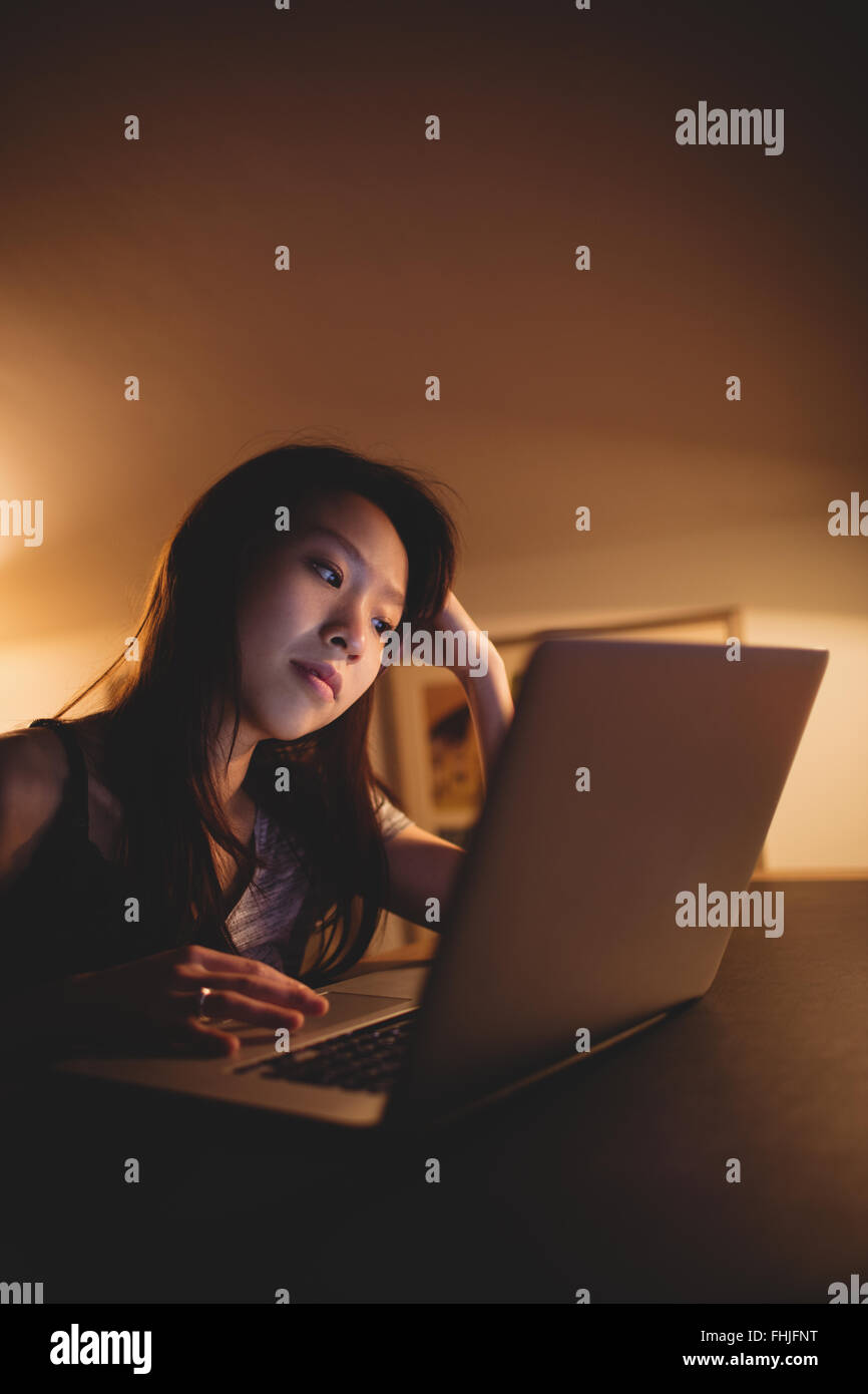 Brunette using laptop on desk Banque D'Images