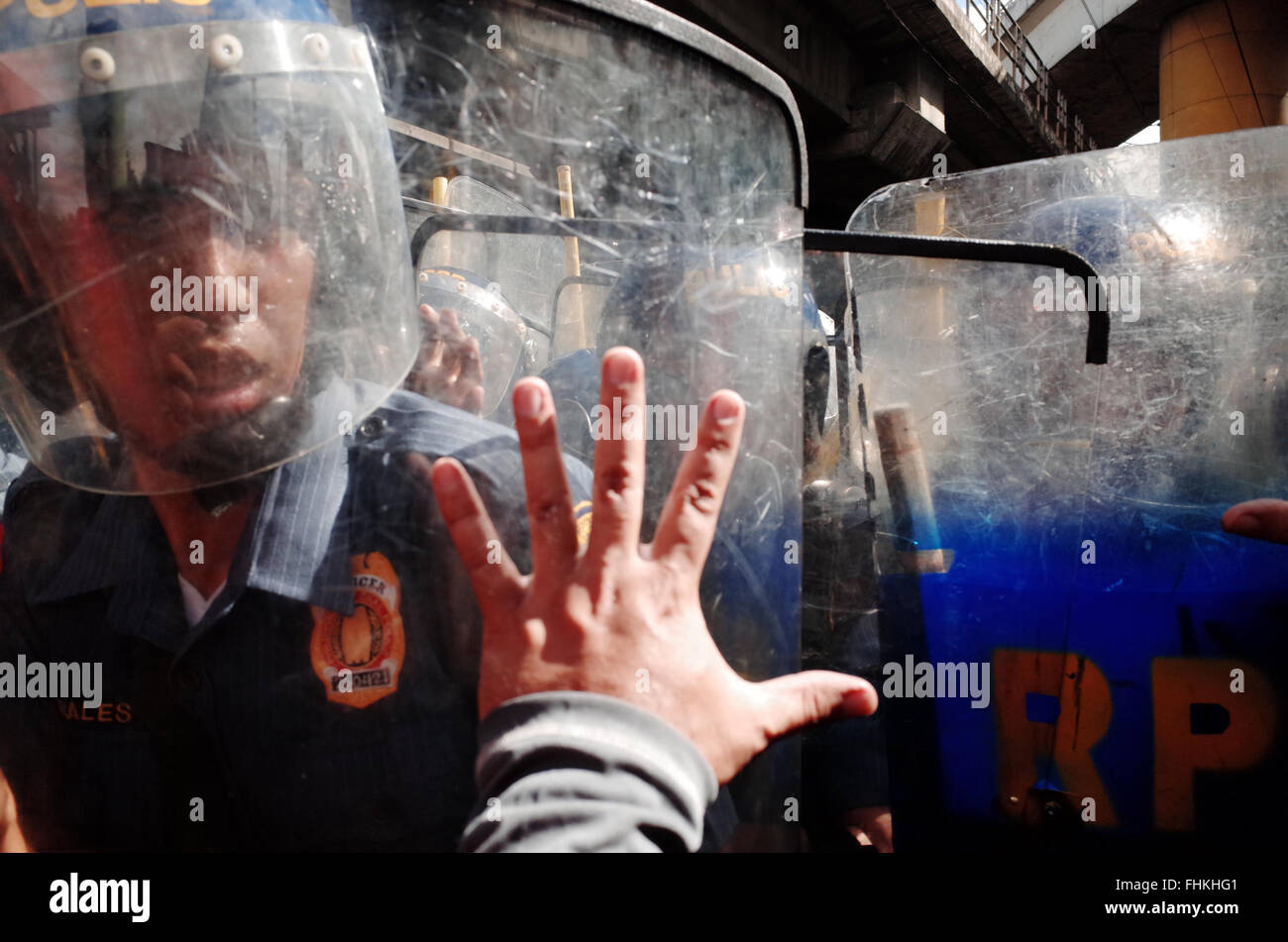 Manille, Philippines. 25 Février, 2016. Un manifestant des signaux aux policiers avec sa main au cours d'une manifestation à l'occasion du 30e anniversaire de la révolution de l'alimentation, qui commémore la chute de la dictature de Ferdinand Marcos, la présidente des Philippines à Mandaluyong City, à l'est de Manille, aux Philippines. Les manifestants disent que peu de choses ont changé depuis la révolution le pouvoir du peuple, disant qu'il .'a renversé un dictateur mais réinstallé une succession de pro-US, les régimes anti-peuple de l'élite Crédit : PACIFIC PRESS/Alamy Live News Banque D'Images