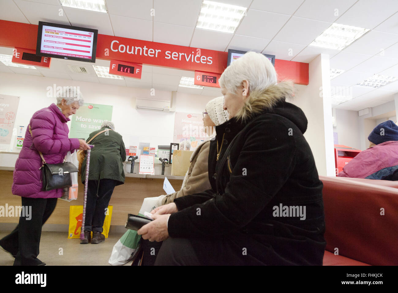 Les personnes en attente dans le système de file d'attente pour les services au comptoir, Cambridge Bureau de poste, Cambridge en Angleterre UK Banque D'Images