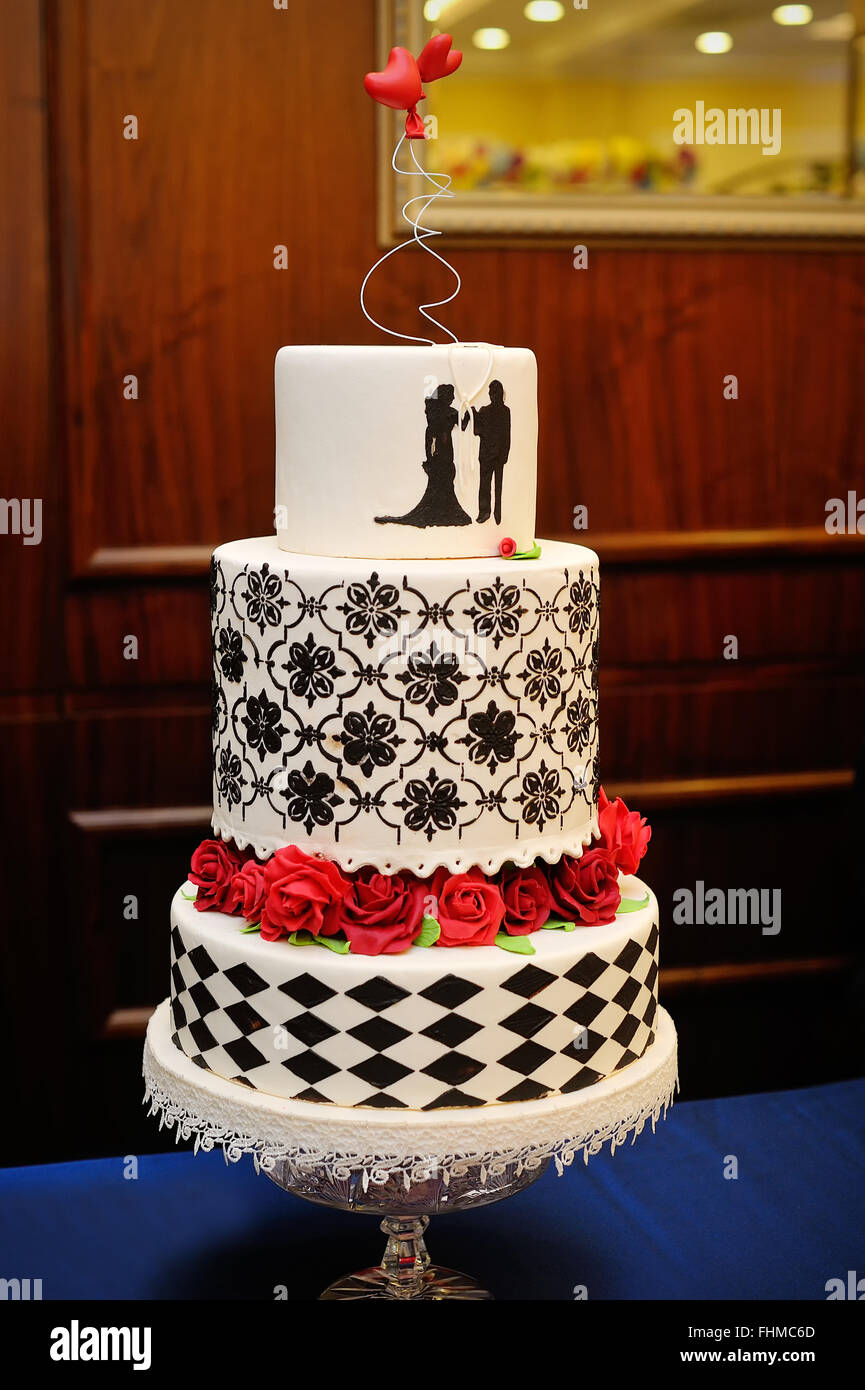 Trois niveaux de gâteau de mariage bleu et blanc avec roses confiserie Banque D'Images