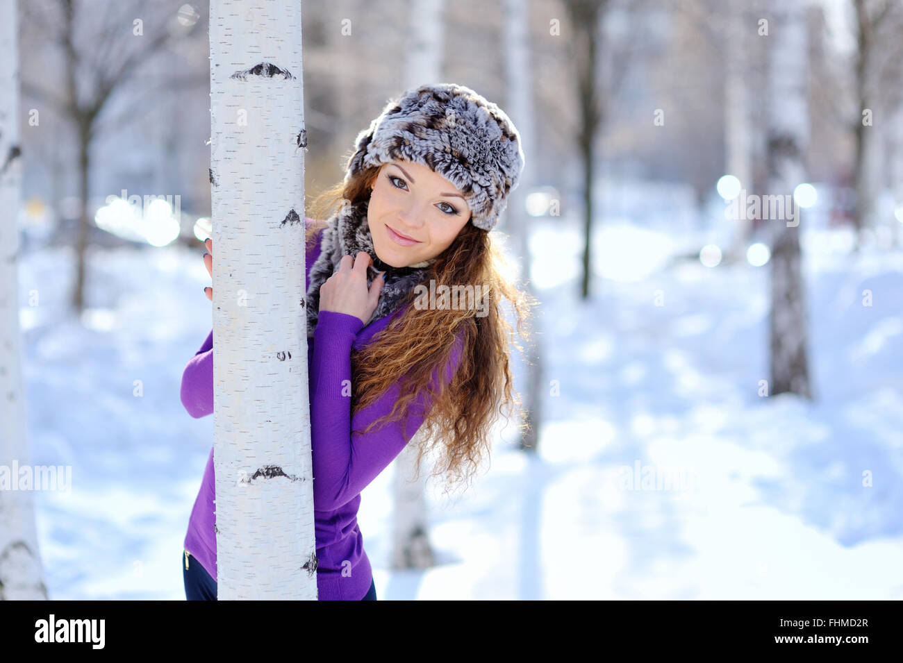 Belle jeune fille debout près de Birch Tree in winter park Banque D'Images