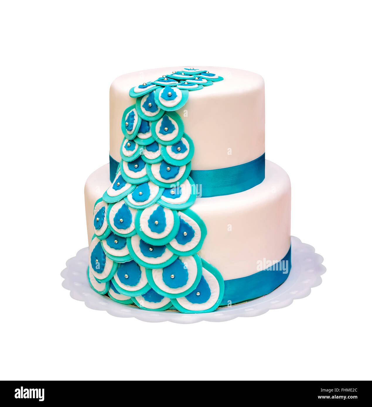 Beau gâteau à deux niveaux avec rubans turquoise isolés. Banque D'Images
