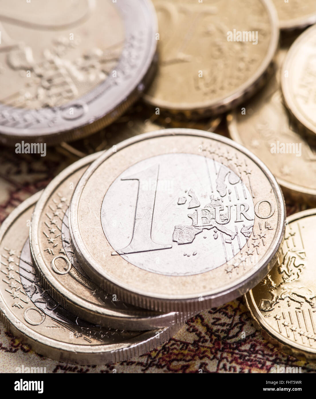 Pièces en euro sur la vieille carte du monde. Photo Macro. Banque D'Images