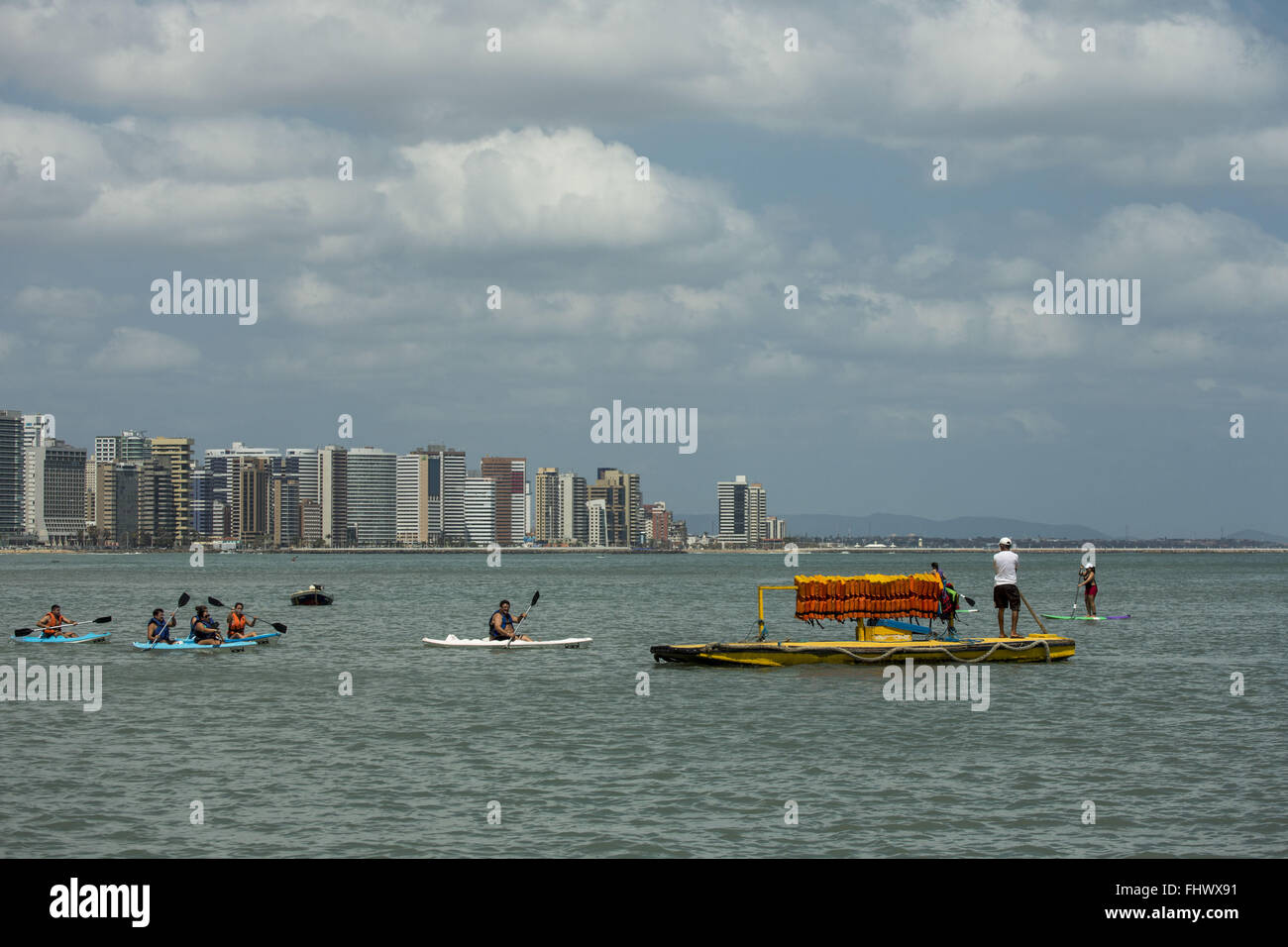 Pratiquer le canoë et le raft avec des gilets de sauvetage - l'arrière-plan des bâtiments sur le bord de la plage d'Iracema Banque D'Images