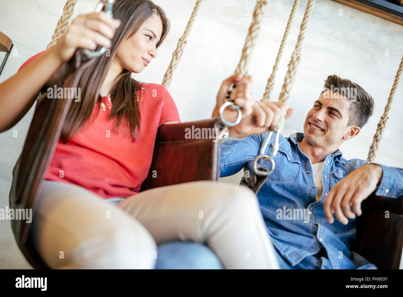 Young couple relaxing in swing tout en parlant et le flirt Banque D'Images