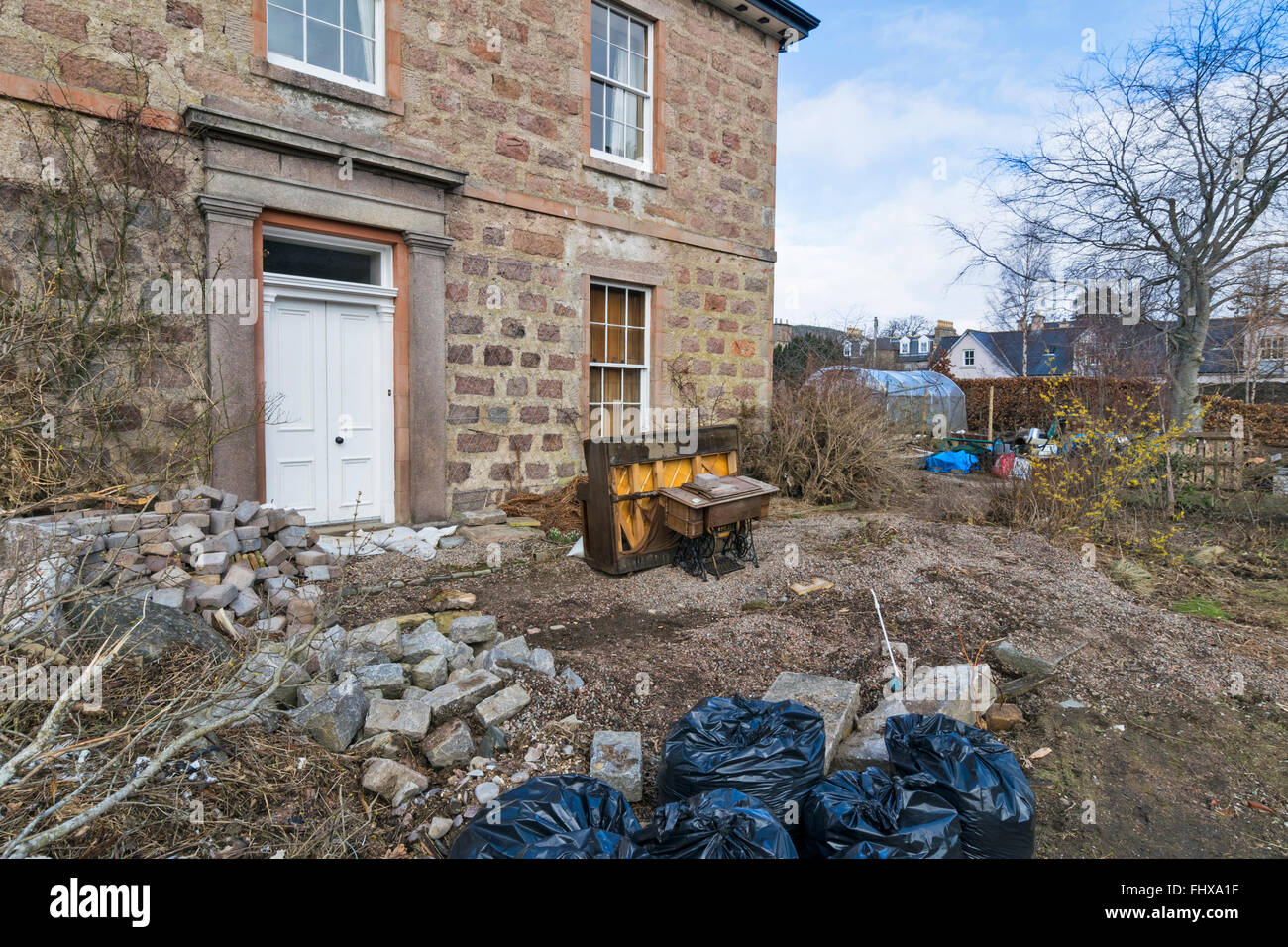 BALLATER ABERDEENSHIRE DEE LES DÉGÂTS des gravats ET DES PIERRES DANS UN JARDIN ET ENDOMMAGÉ UN VIEUX PIANO Banque D'Images