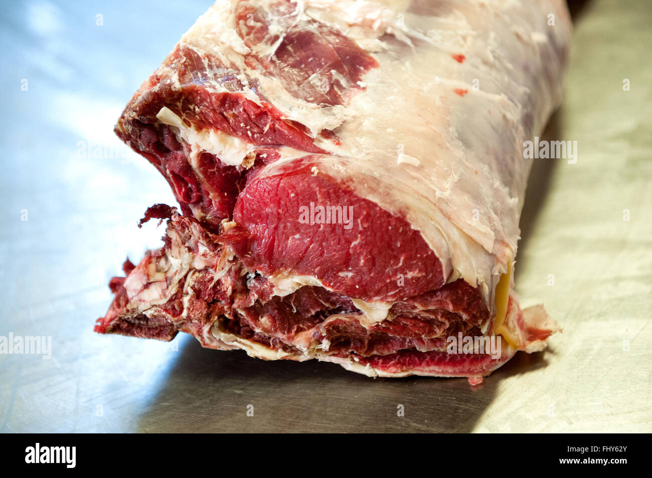 Close up de coupe de viande bovine crue dans la forme d'une jambe sur la table en acier Banque D'Images