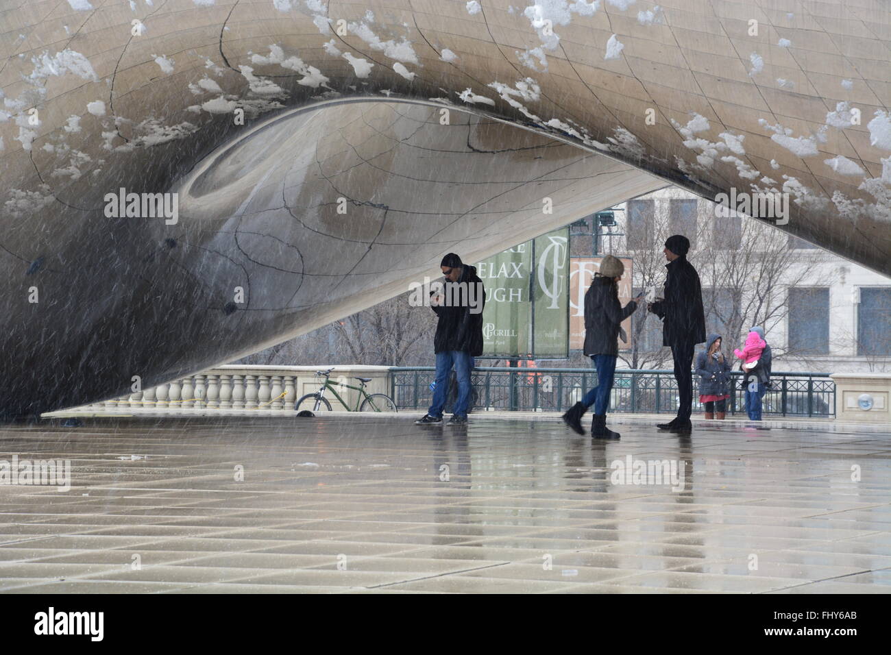 Les touristes en hiver, vérifiez leur reflet dans le bean ou cloud gate sculpture dans le parc du millénaire, chicago Illinois. Banque D'Images