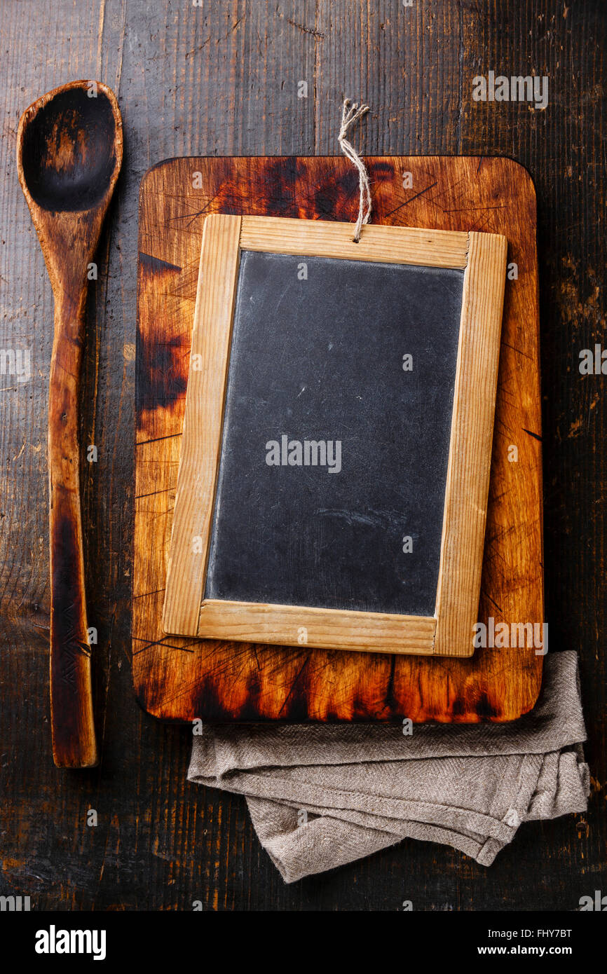 Planche à découper cuillère en bois ancien et Vintage chalk board ardoise foncé sur fond de bois Banque D'Images