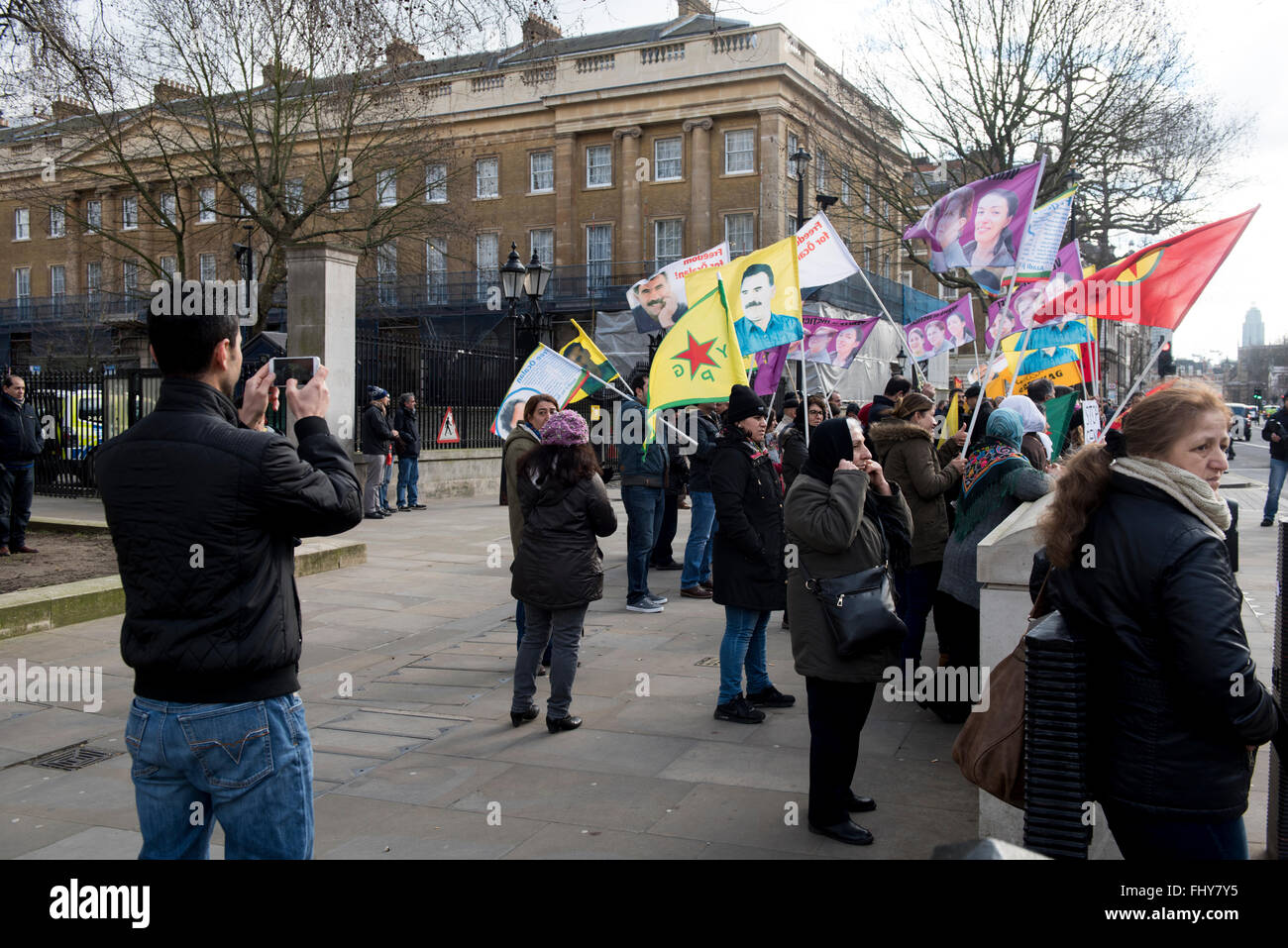 Manifestant est à prendre des photos avec le téléphone de ses amis pendant la manifestation kurde à l'extérieur de la Downing Street, London, UK. Banque D'Images