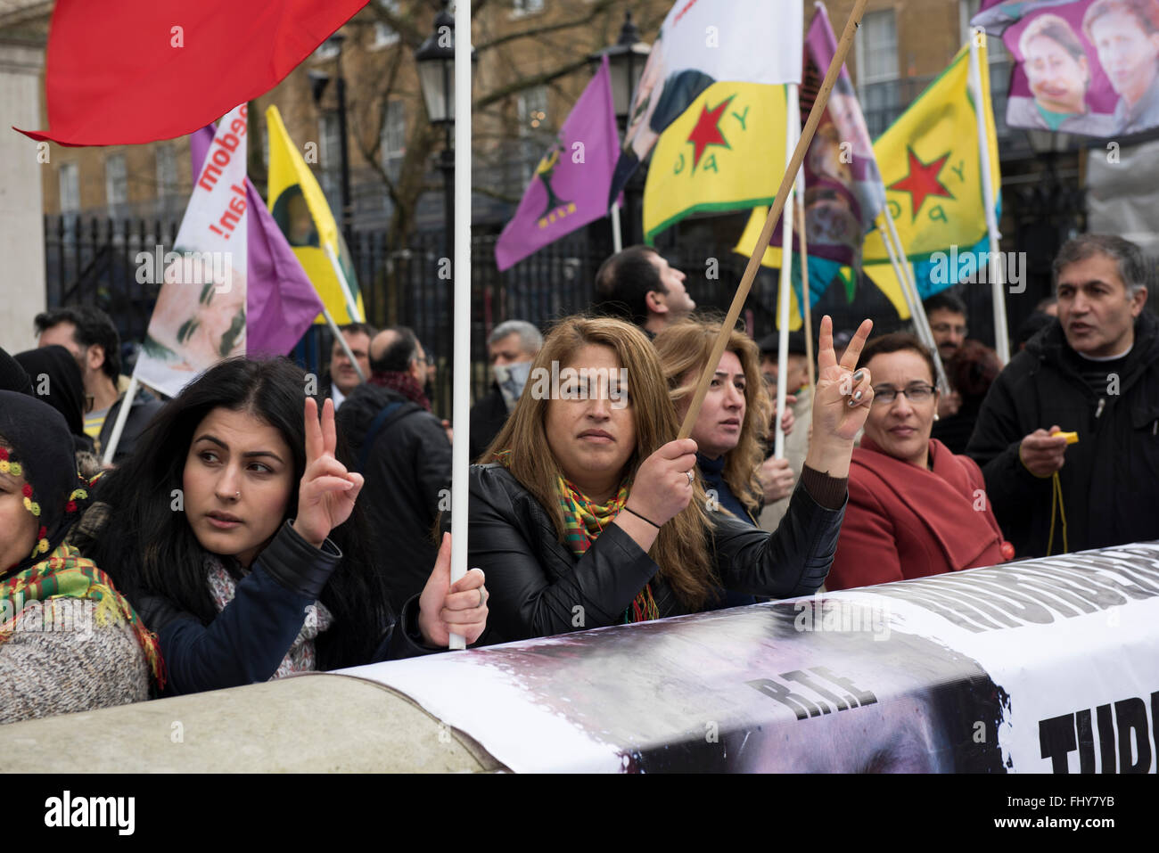 Les femmes sont agitant des drapeaux et feux les signes de paix au cours de la manifestation kurde à l'extérieur de la Downing Street, London, UK. Banque D'Images