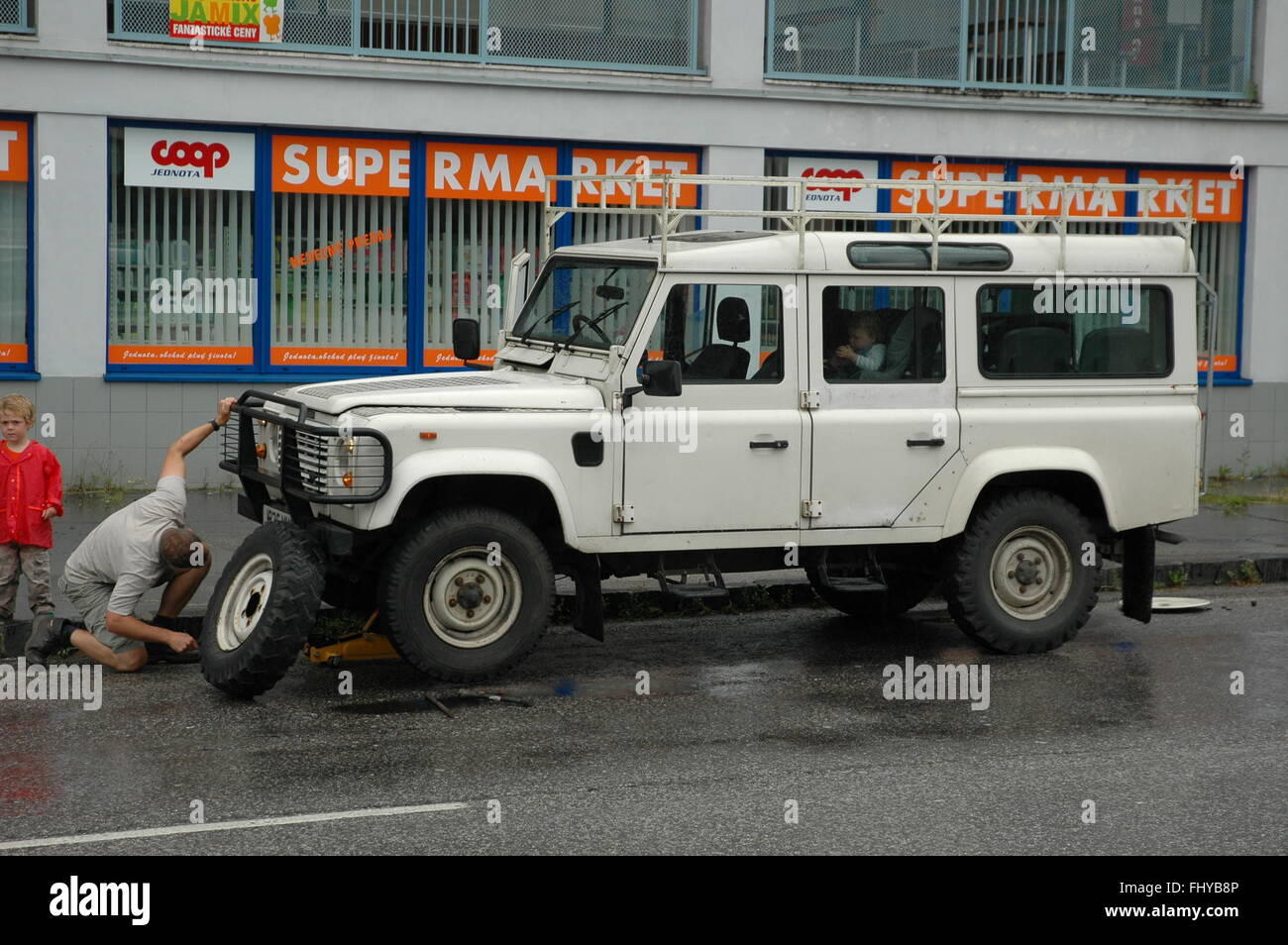 Oops - pneu à plat, changement de roue sur Landrover Defender Banque D'Images Oops - pneu à plat, changement de roue sur Landrover Defender Banque D'Images