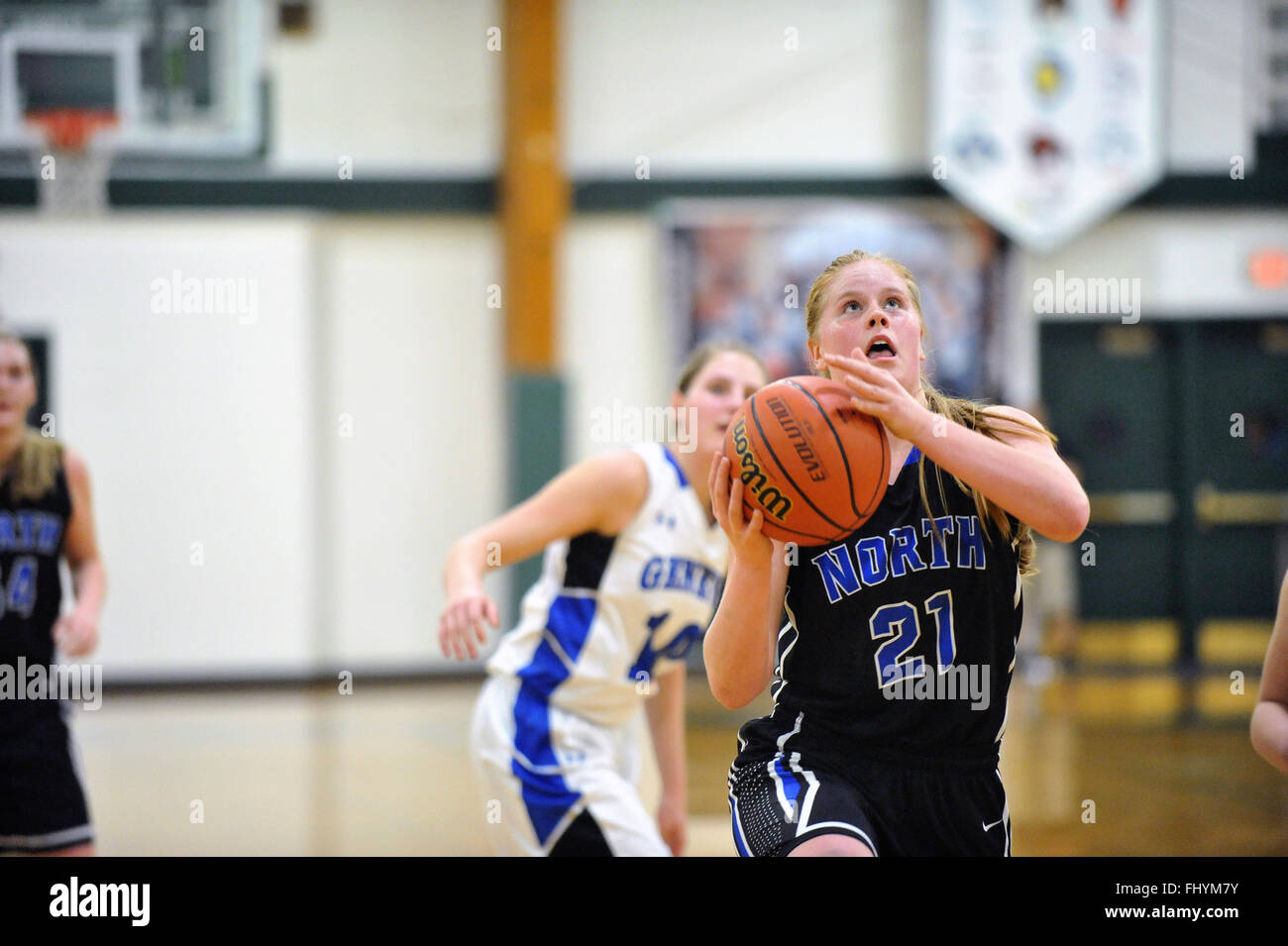 Avec un regard sur le panier, un joueur se prépare à lancer un effort de notation lors d'un match de basket-ball de l'école secondaire. USA. Banque D'Images