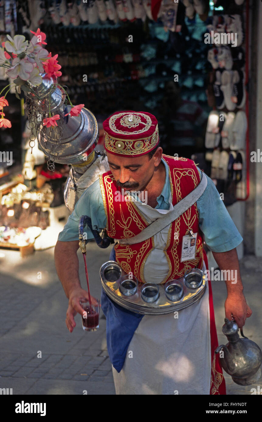 Jus traditionnel turc vendeur verse sa buvette de son pot géant - Bazar, Istanbul, Turquie Banque D'Images