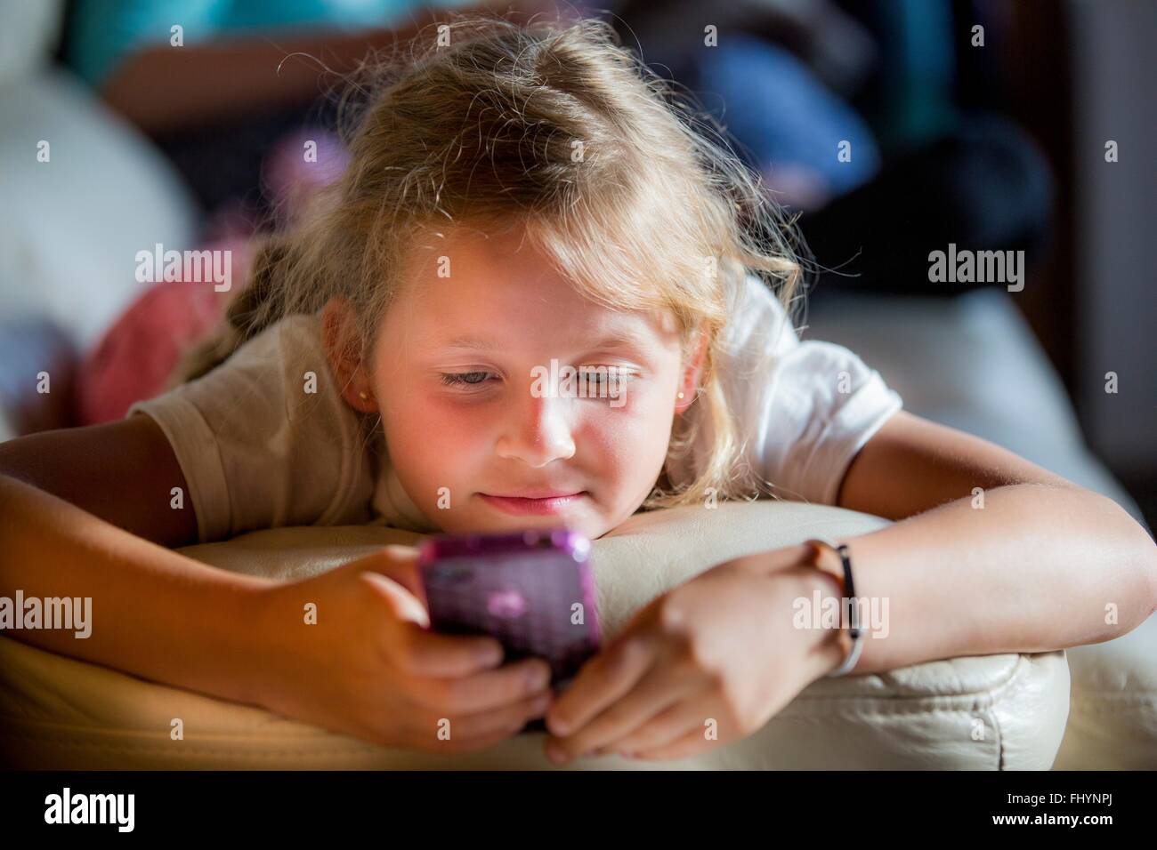 Parution du modèle. Girl lying on her face à l'aide d'un smartphone. Banque D'Images
