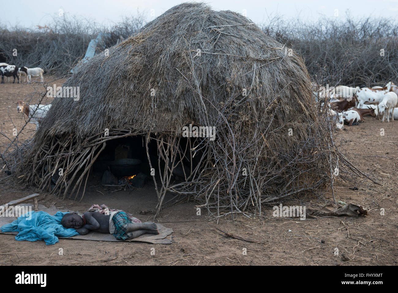 L'ETHIOPIE, le sud de l'ONU, vallée de l'Omo, Kangaten, village Kakuta, tribu Nyangatom, dormir garçon en face de hut Banque D'Images