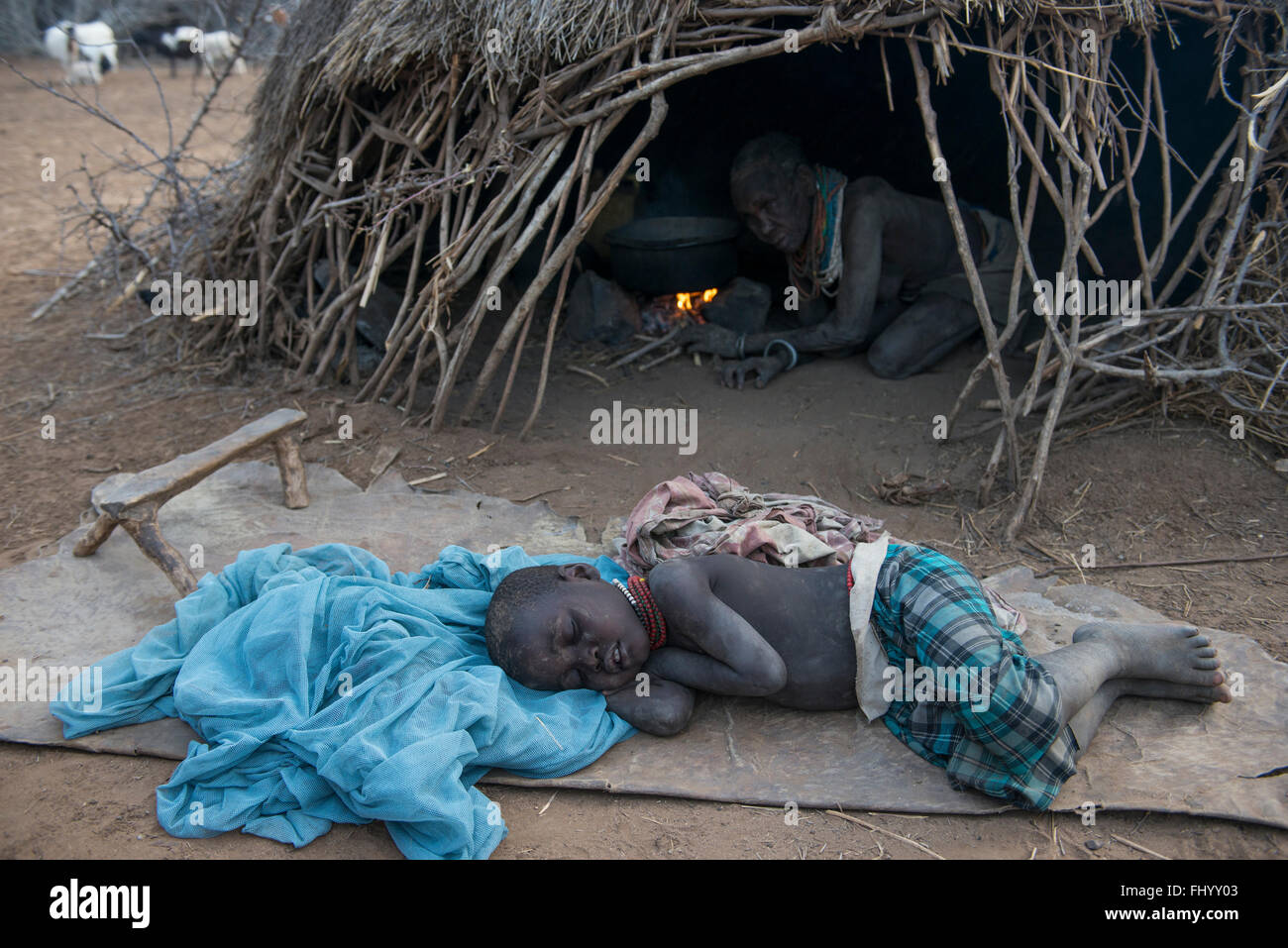 L'ETHIOPIE, le sud de l'ONU, vallée de l'Omo, Kangaten, village Kakuta, tribu Nyangatom, dormir garçon en face de hut Banque D'Images