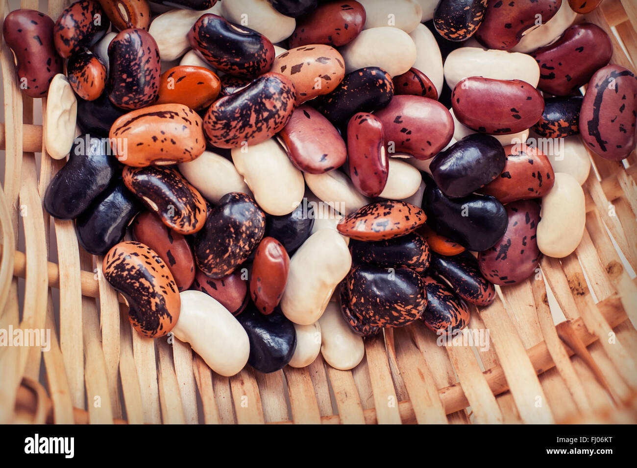 Les haricots colorés dans un panier en osier de près. Banque D'Images