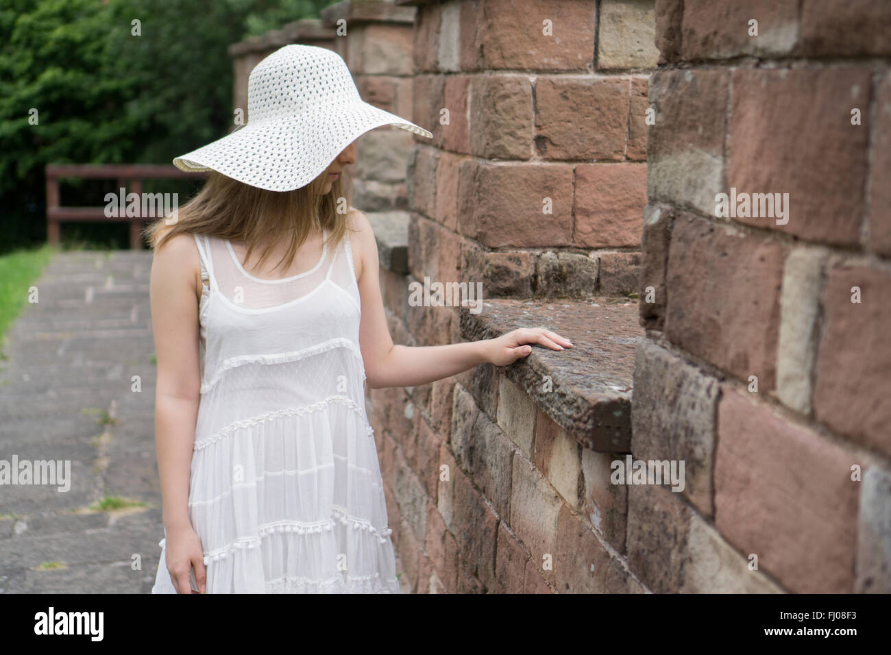 Femme seule dans une robe blanche standing outdoors Banque D'Images
