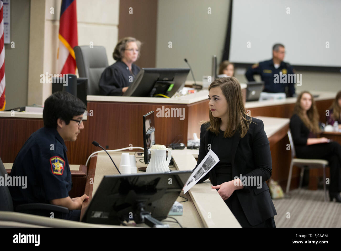 Se faisant passer pour l'avocat de la défense de l'adolescence de l'adolescence questions posant comme agent de police de procès simulé pour les élèves du secondaire de TX d'audience Banque D'Images