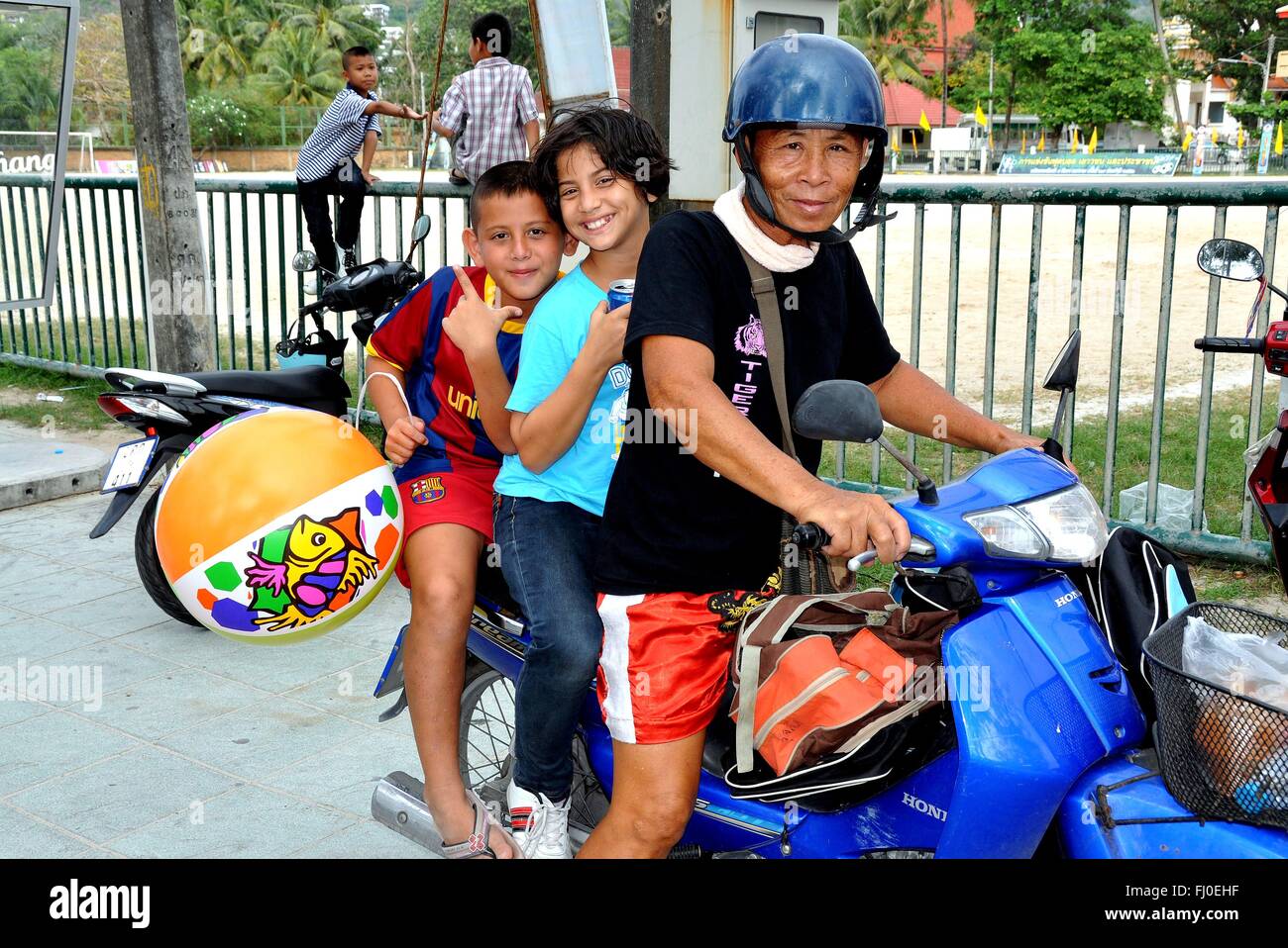Patong City / Phuket, Thaïlande : Thai grand-père avec ses petits-enfants à cheval sur un cyclomoteur Banque D'Images