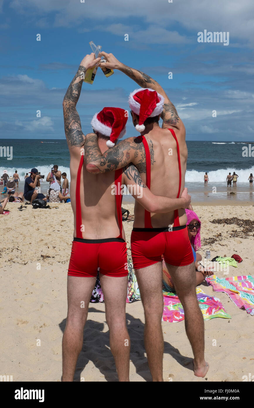 Men toasting un joyeux noël sur Coogee Beach, Sydney, New South Wales, Australia Banque D'Images