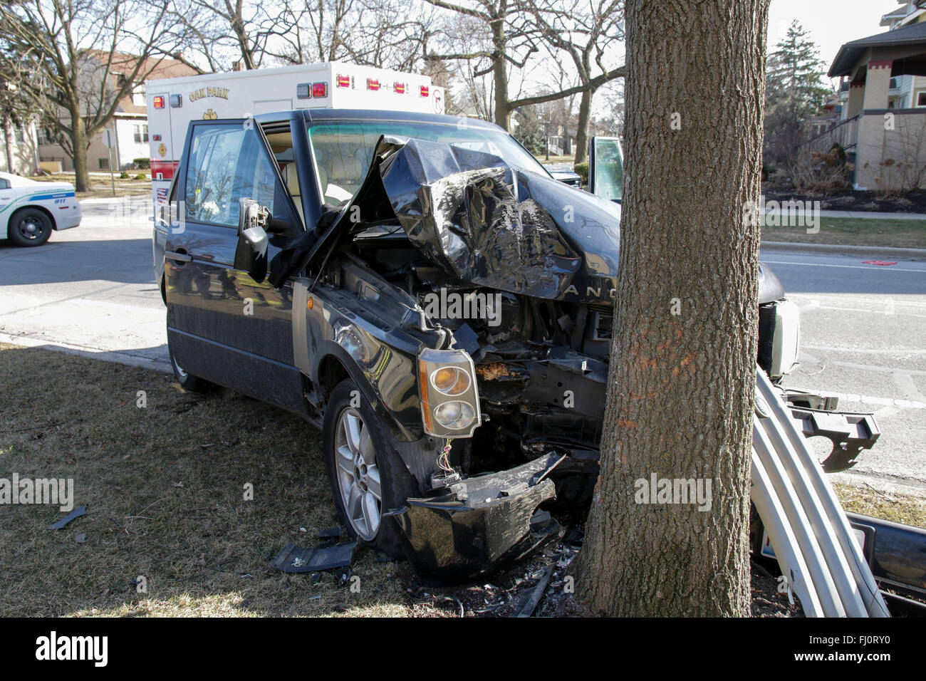 Oak Park, Illinois, USA. 27 février 2016. Une Range Rover se repose sur un arbre de la promenade froissé à l'intersection de la rue Division et Elmwood Ave dans cette banlieue ouest de Chicago. De toute évidence, les SUV ont quitté la route sans ralentir, conduisant à de graves dommages et l'extrémité avant des débris de la voiture roulant tout à fait un peu plus loin le long de la Division. Heureusement, il n'y a pas eu de blessures graves pour le conducteur et les passagers, dont un bébé dans un siège de voiture. Les zones fusibles et airbags dans cette automobile moderne dans toute la probabilité de sauver des vies. Credit : Todd Bannor/Alamy Live News Banque D'Images