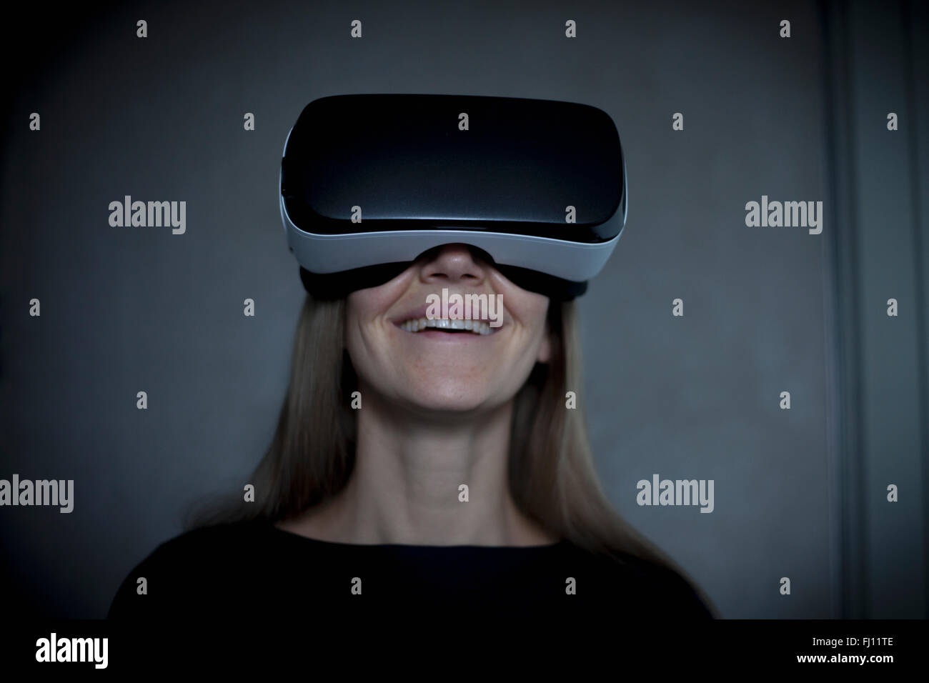 Smiling woman wearing lunettes de réalité virtuelle Banque D'Images
