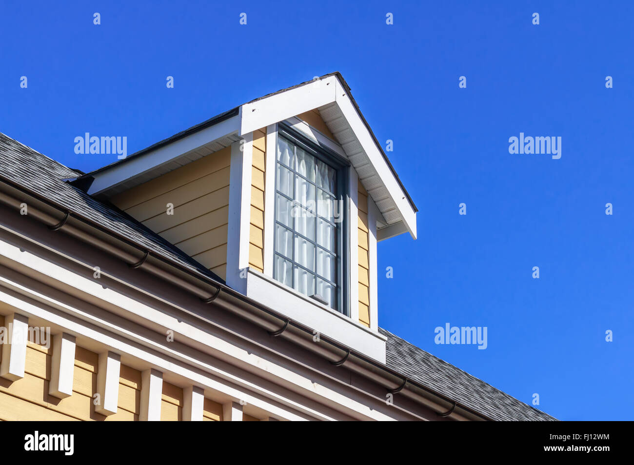 Lucarne sur la nouvelle maison, avec ciel bleu en arrière-plan Banque D'Images