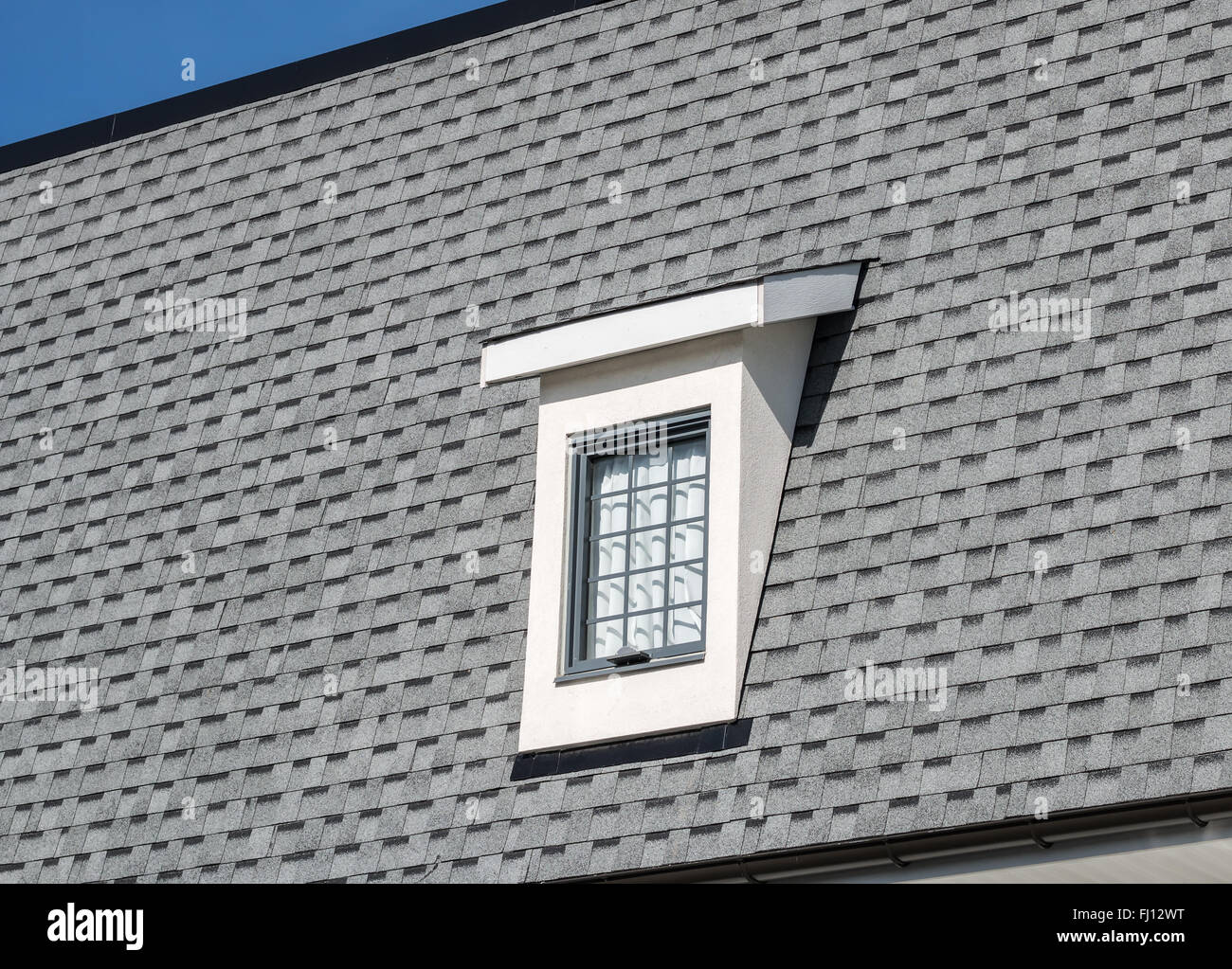 Lucarne sur la nouvelle maison, avec ciel bleu en arrière-plan Banque D'Images