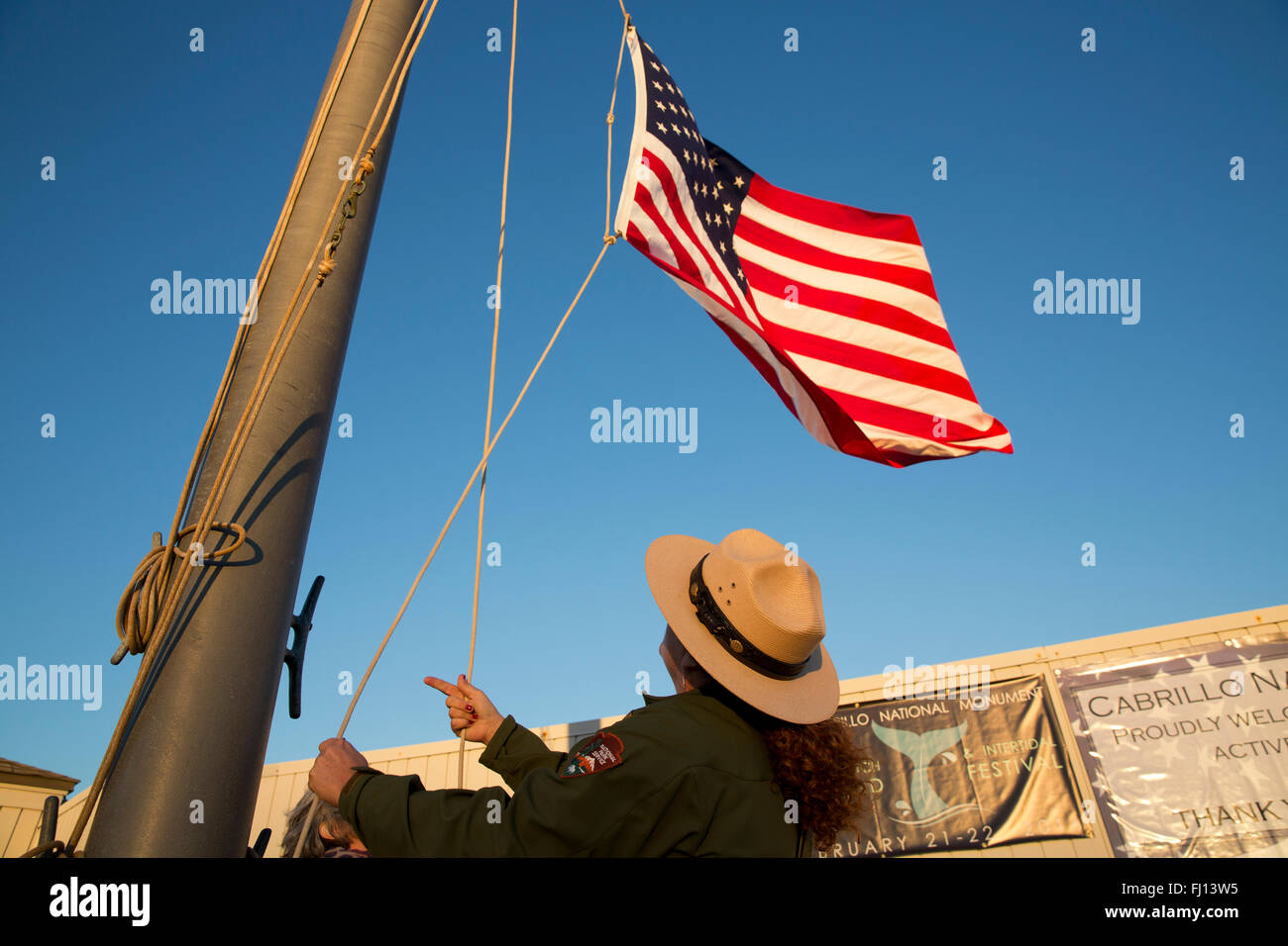 Un garde forestier du parc s'abaisse le drapeau, Cabrillo National Monument, San Diego Californie Banque D'Images