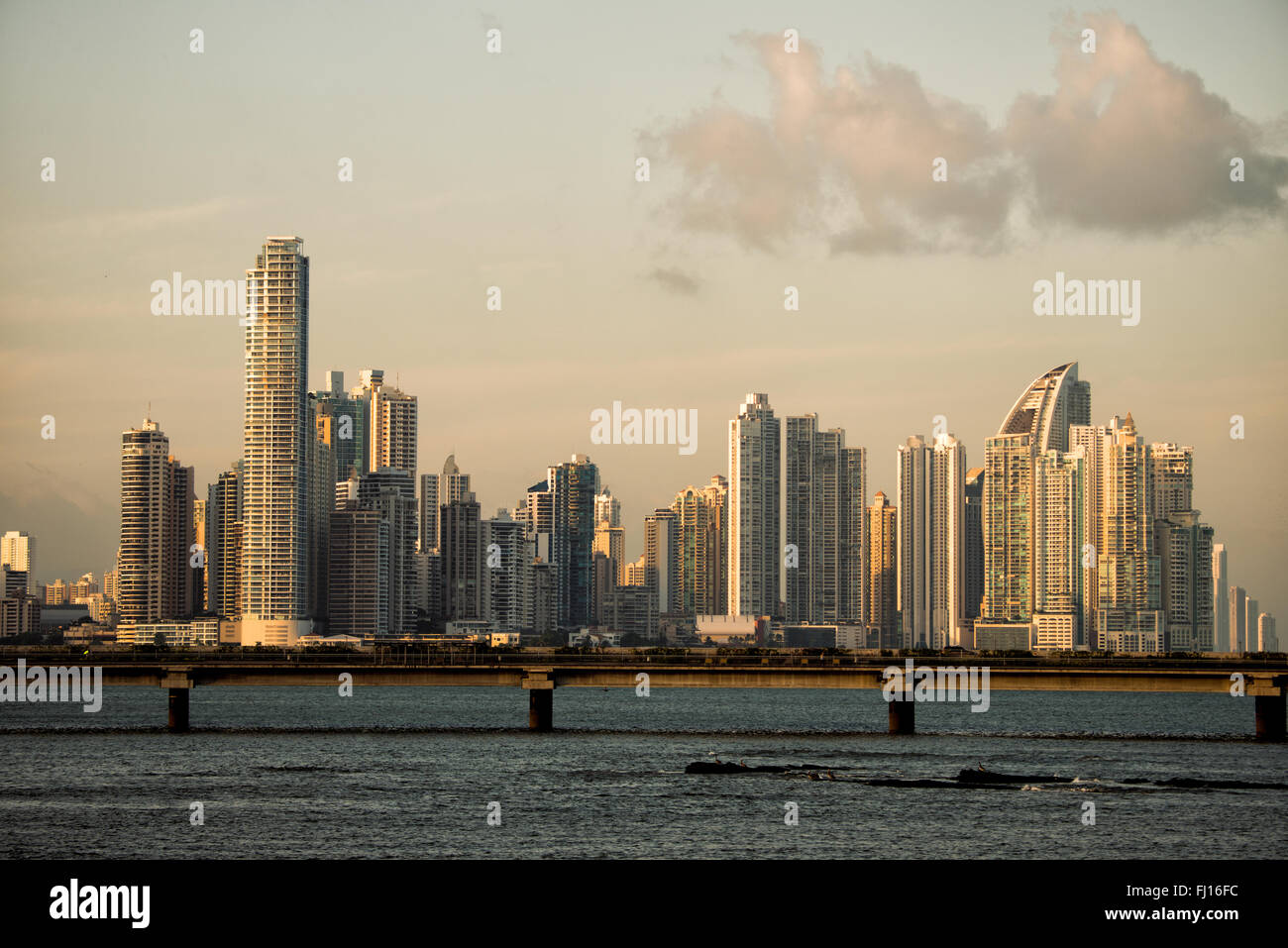 PANAMA CITY, Panama — la lueur dorée décroissante du soleil couchant attrape les gratte-ciel modernes de la ligne d'horizon du quartier Punta Paitilla de Panama City, Panama. Au premier plan se trouve la controversée ceinture côtière (Cinta Costera III) qui fait le tour de Casco Viejo. Banque D'Images