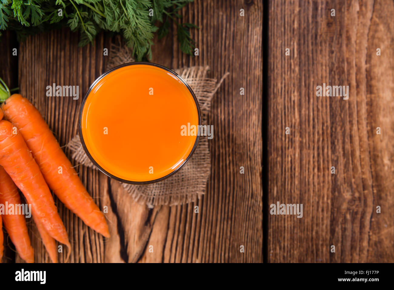 Partie de jus de carotte sur une vieille table en bois (selective focus) Banque D'Images