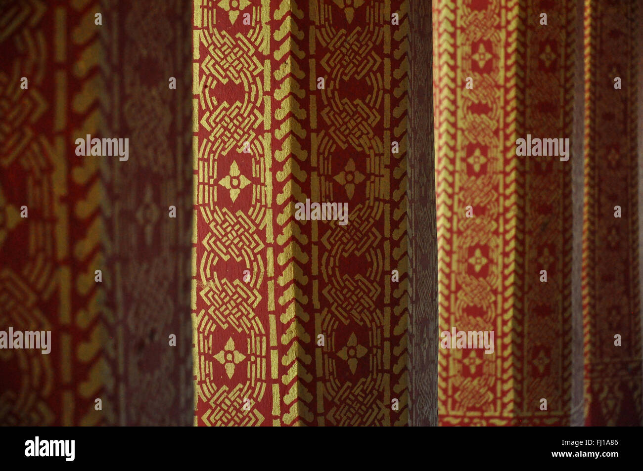 Détail de l'architecture : rouge et or piliers, temple bouddhiste, Luang Prabang, Laos Banque D'Images