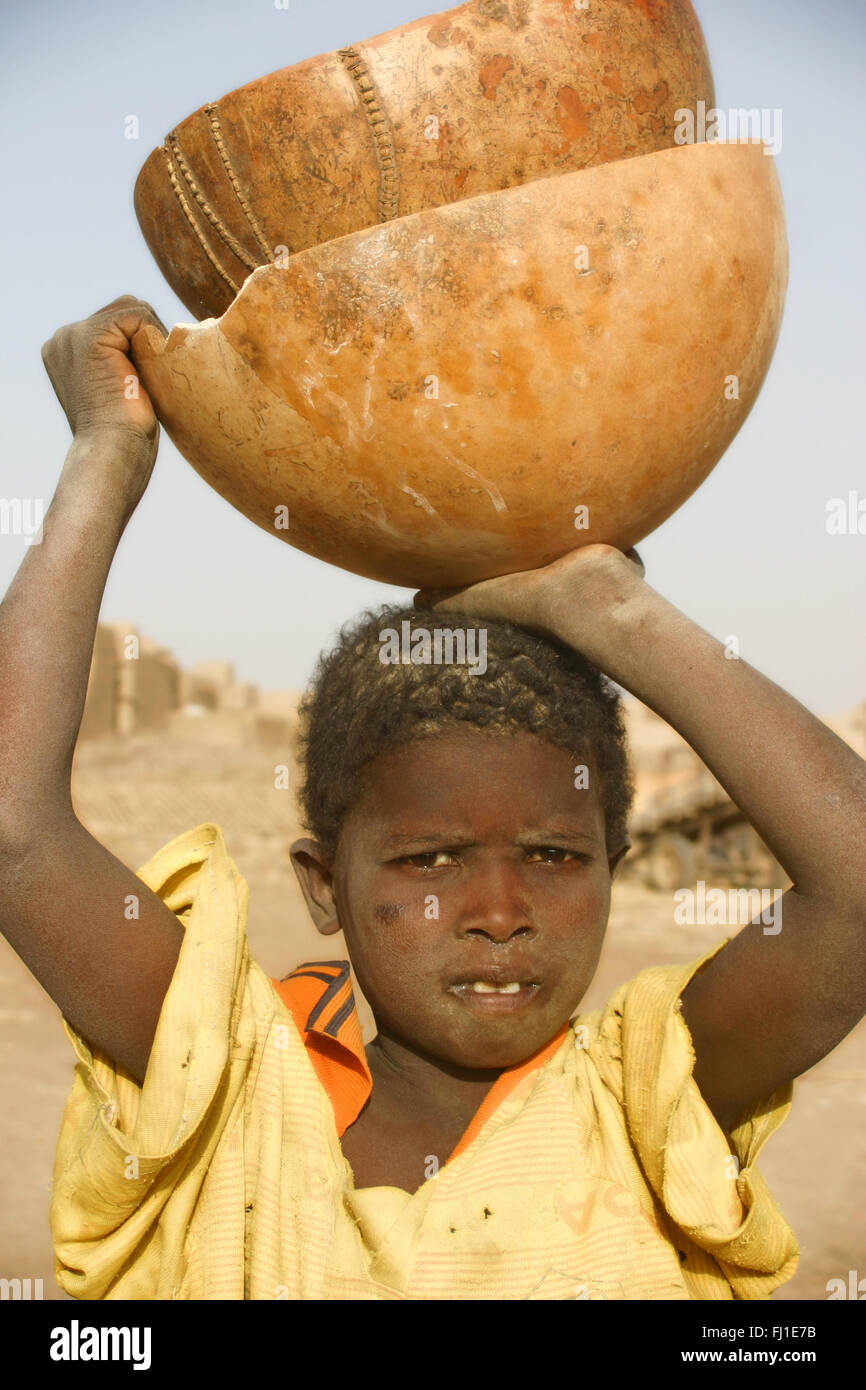 Portrait de l'enfant africain porteur d'une calebasse à Djenné, Mali Banque D'Images