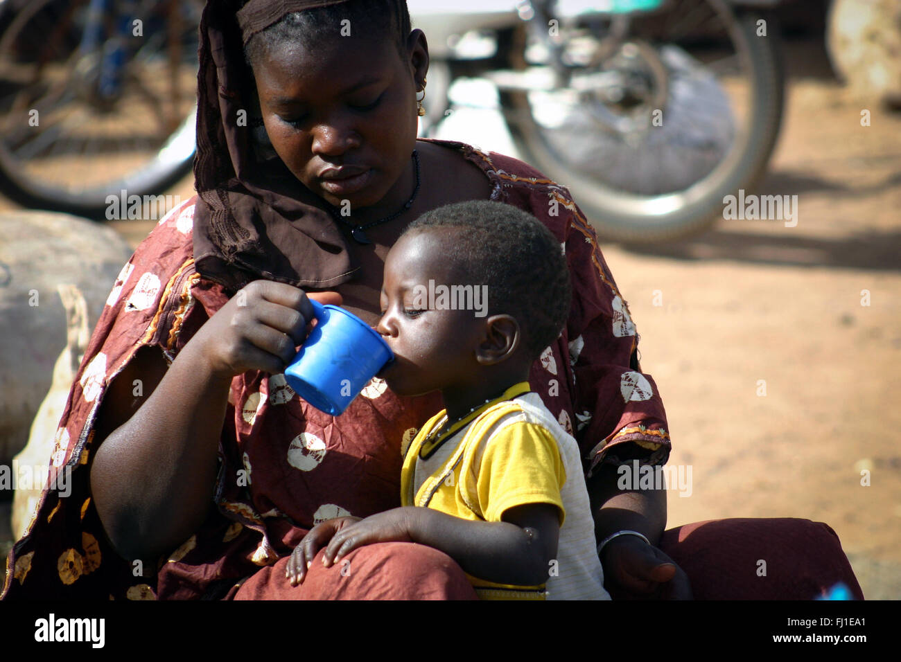 Donner de l'eau mère malienne / nourrir son enfant dans le marché de Ségou au Mali Banque D'Images