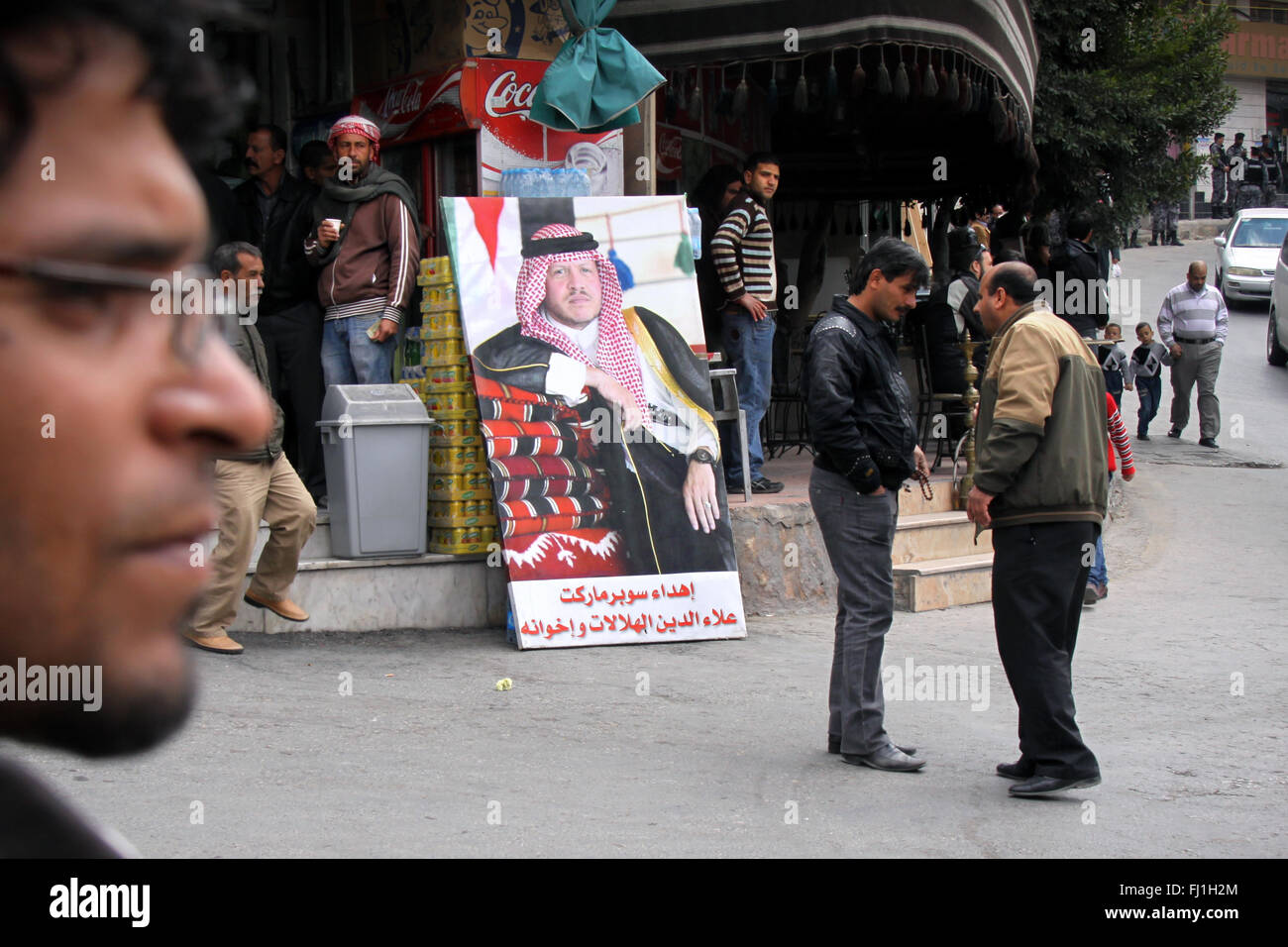 Les gens dans une rue de Wadi Musa, avec portrait du roi Abdallah II de Jordanie Banque D'Images