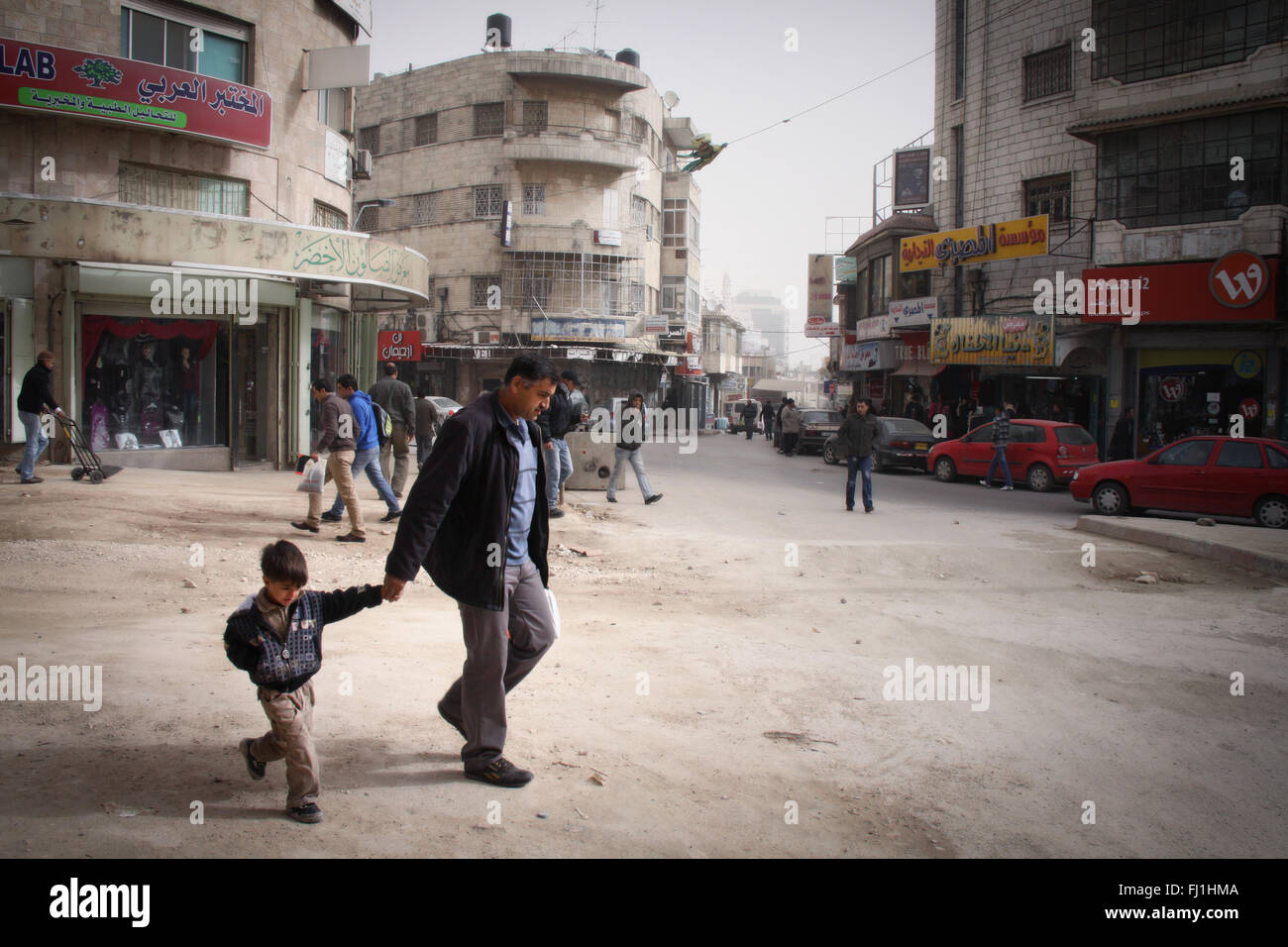Homme marchant avec son fils dans les rues de Ramallah , Palestine Banque D'Images